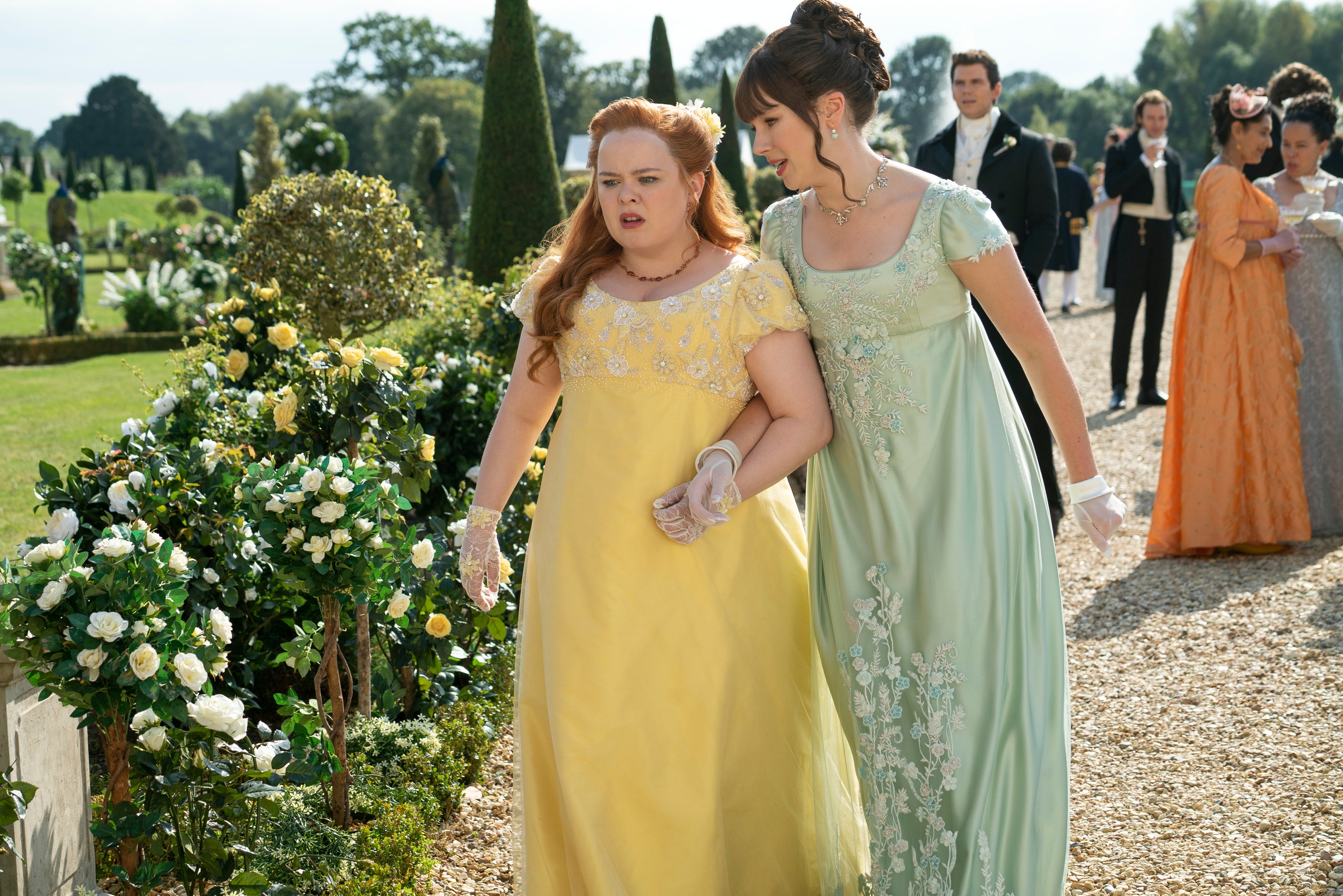 Penelope Featherington (Nicola Coughlan) and Eloise (Claudia Jessie) strolling through the garden in wispy dresses
