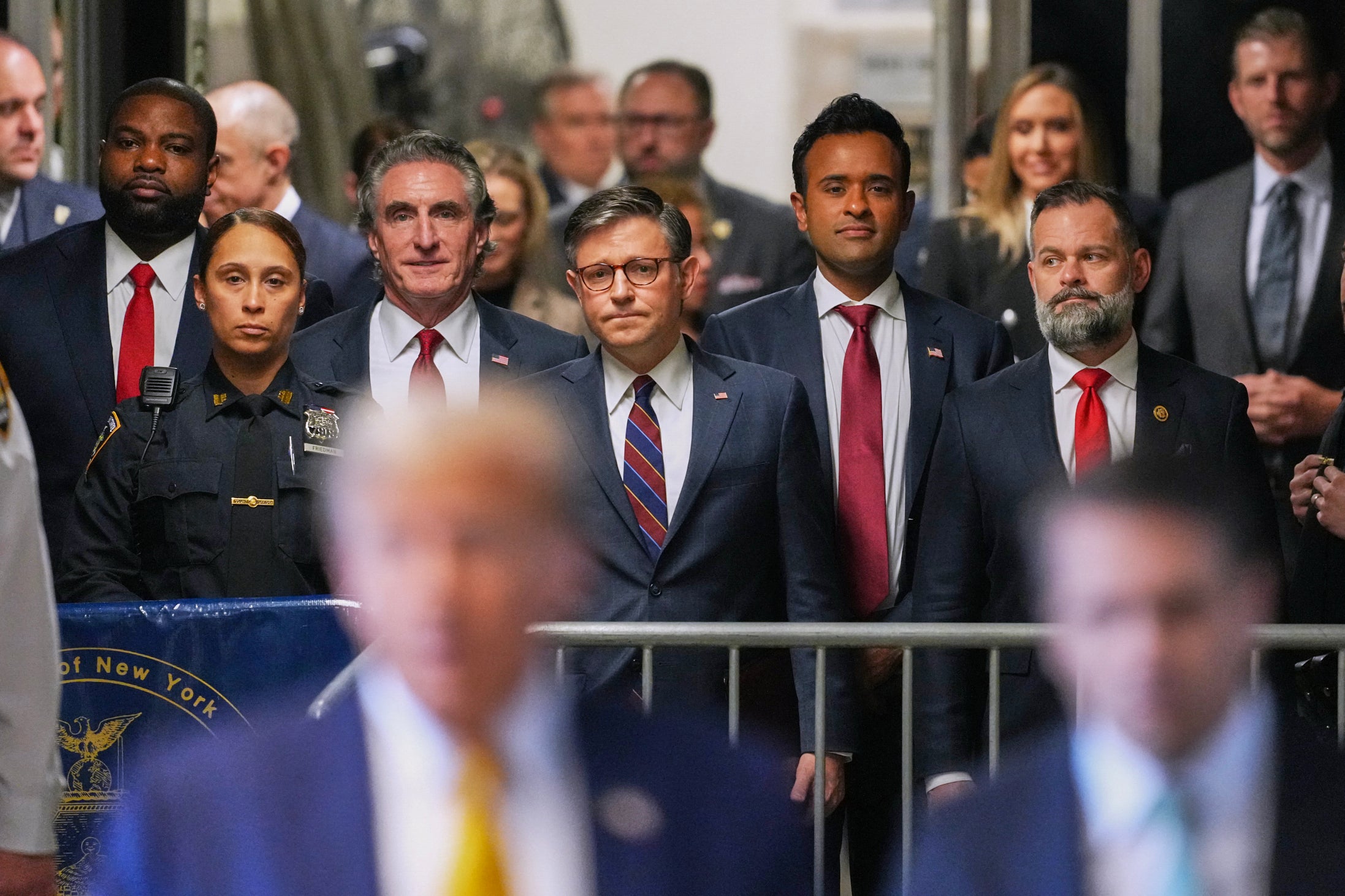 US Rep Byron Donalds, Doug Burgum, House Speaker Mike Johnson, Vivek Ramaswamy and US Rep Cory Mills watch Donald Trump speak in a Manhattan criminal court hallway on 14 May.