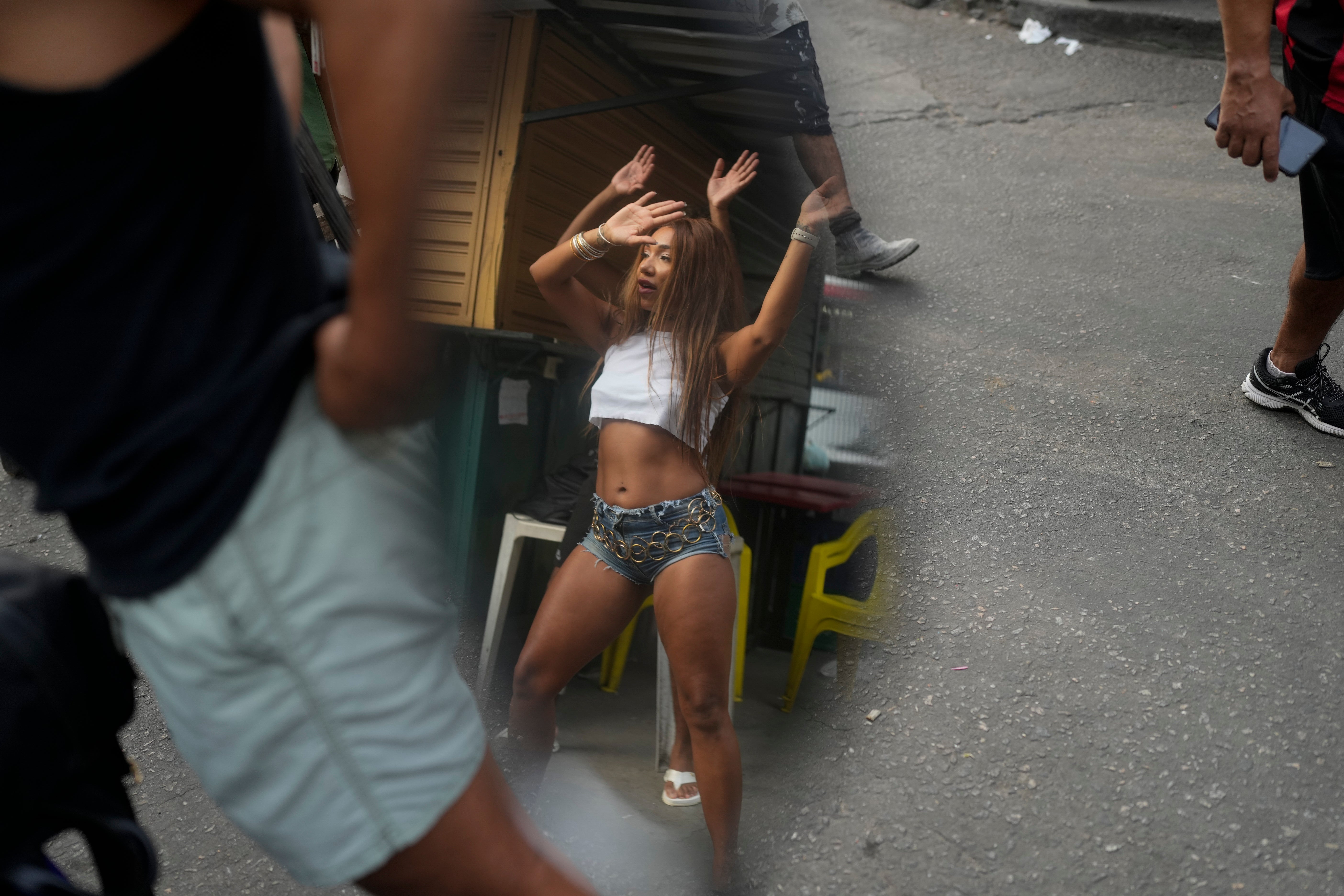 Reflected in a motorcycle side mirror, a woman performs a street dance style known as passinho