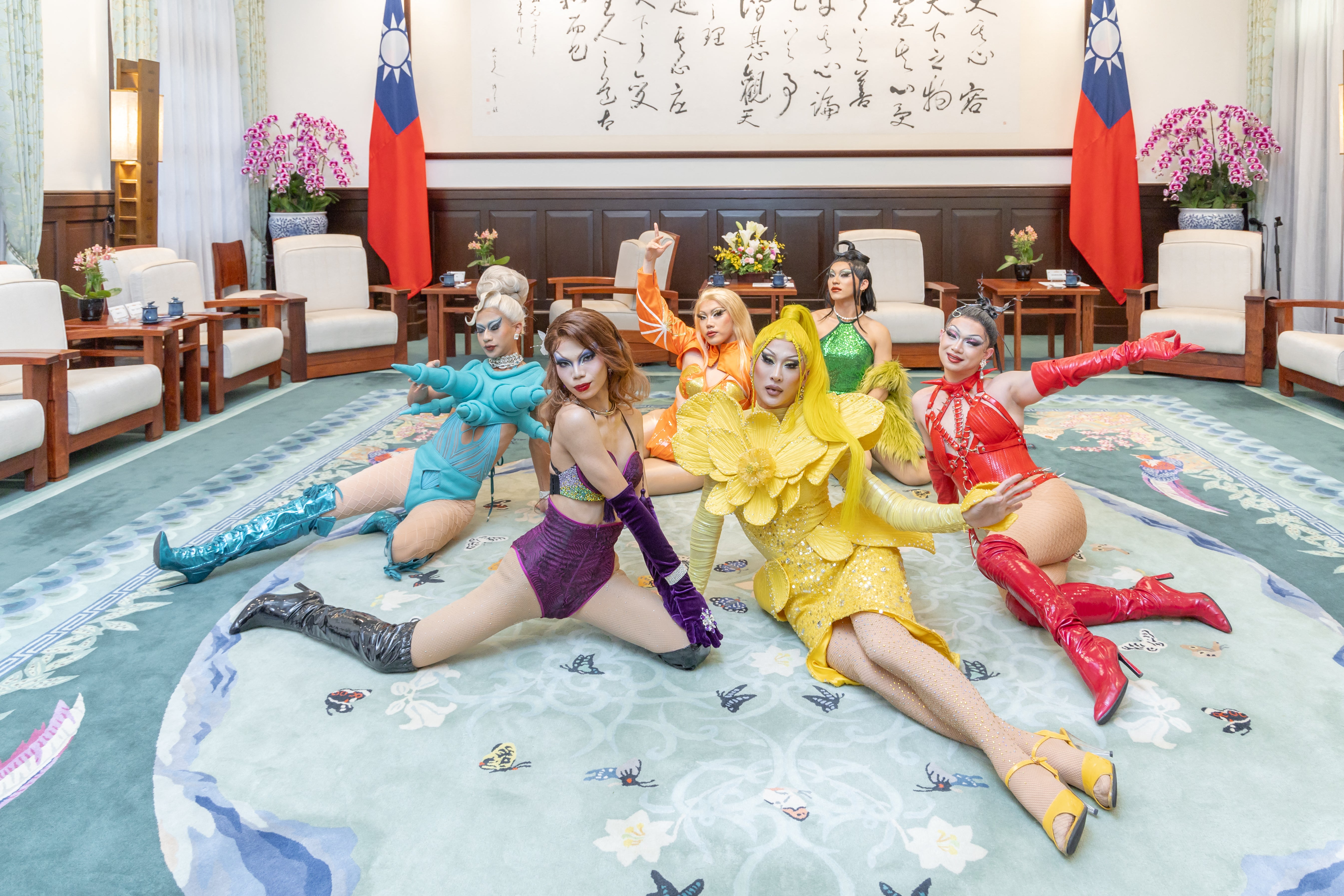 Nymphia Wind, dressed in yellow, and her team pose for photos at the presidential office in Taipei