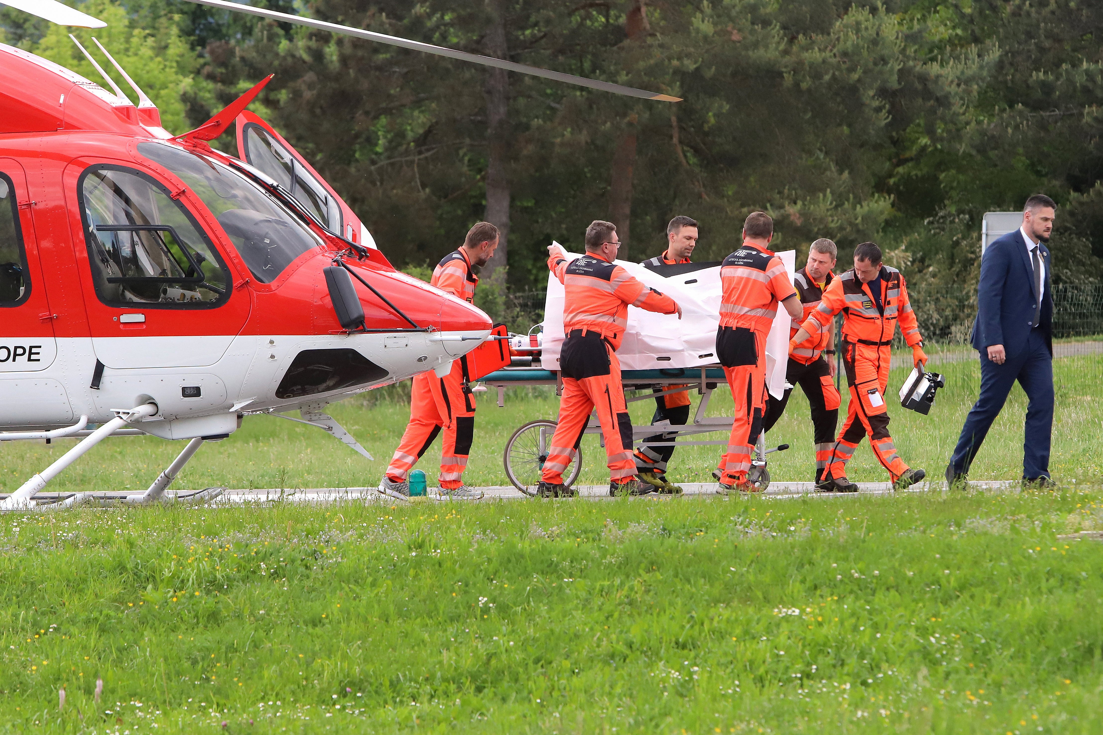 Mr Fico is seen being transported from a helicopter by medics and his security detail to the hospital in Banska Bystrica