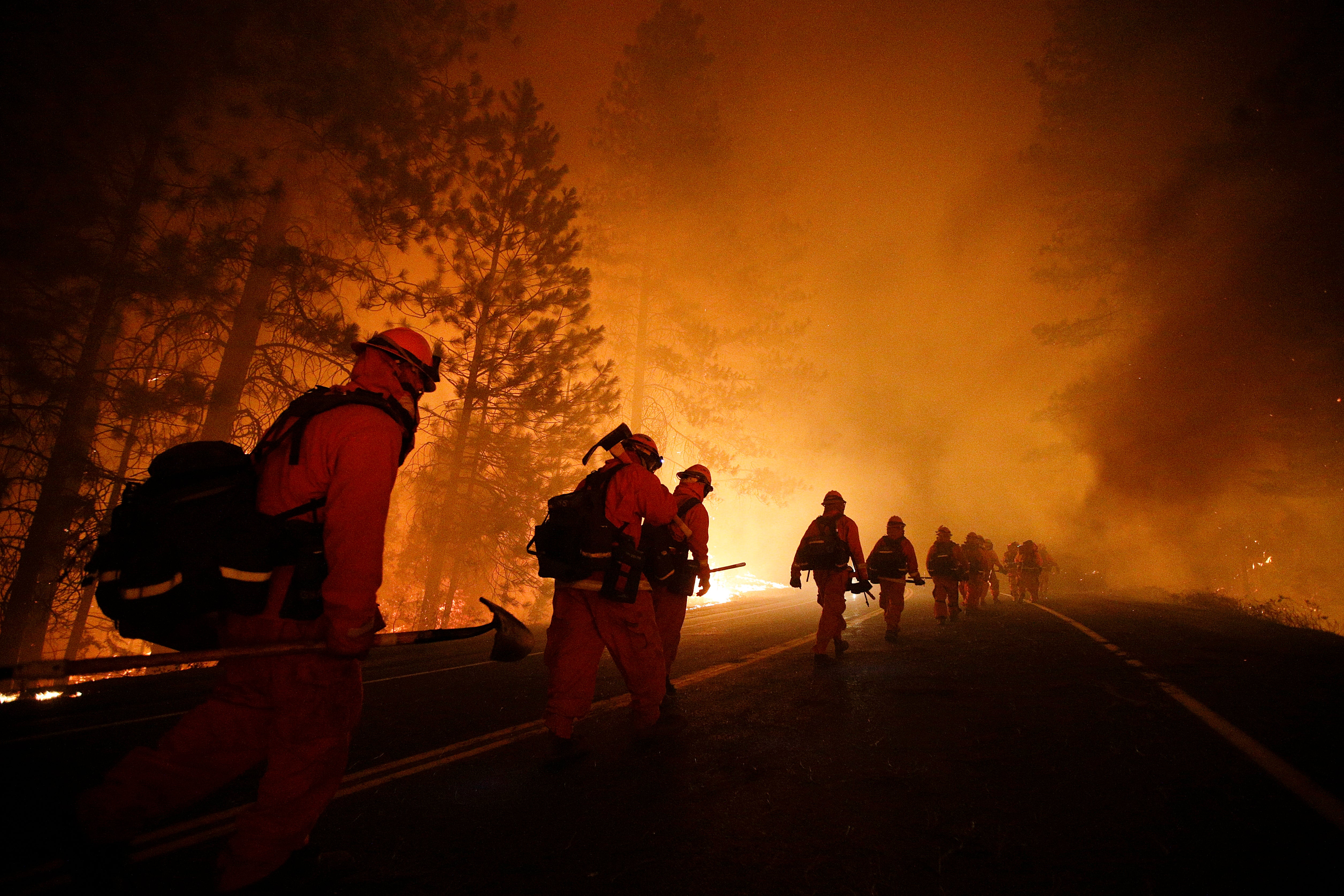 Inmate firefighters walk along Highway 120 after a burnout operation during the Rim Fire near Yosemite National Park, California, in 2013. Crews from prison are helping to fight the blazes currently tearing through Los Angeles