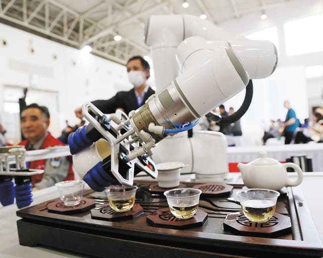 <p>A robot serves tea to visitors during a tea expo in Beijing in April</p>