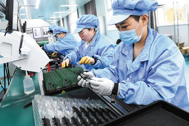 <p>Employees work on a production line of export-bound electronics in Shijiazhuang, Hebei province </p>