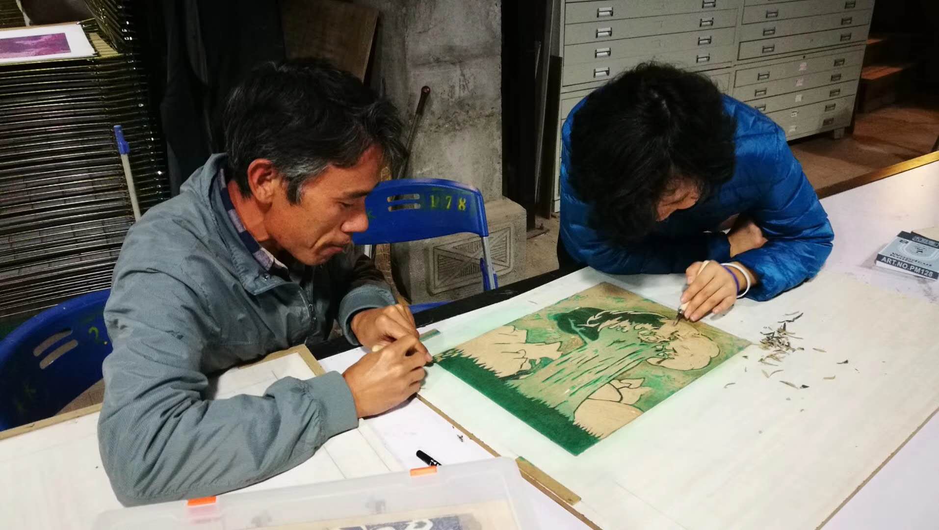 Farmer-painters carve the woodblock at the reduction woodblock print studio in Nakeli village, Pu’er, Yunnan province, in 2017