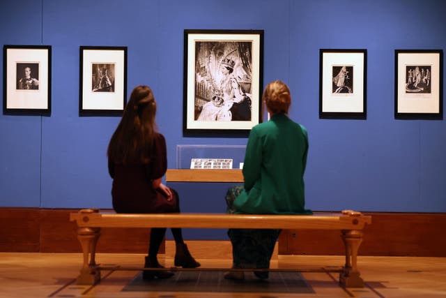 <p>Punonjësit e galerisë shohin fotografitë e Mbretëreshës Elizabeth II nga Cecil Beaton</p>