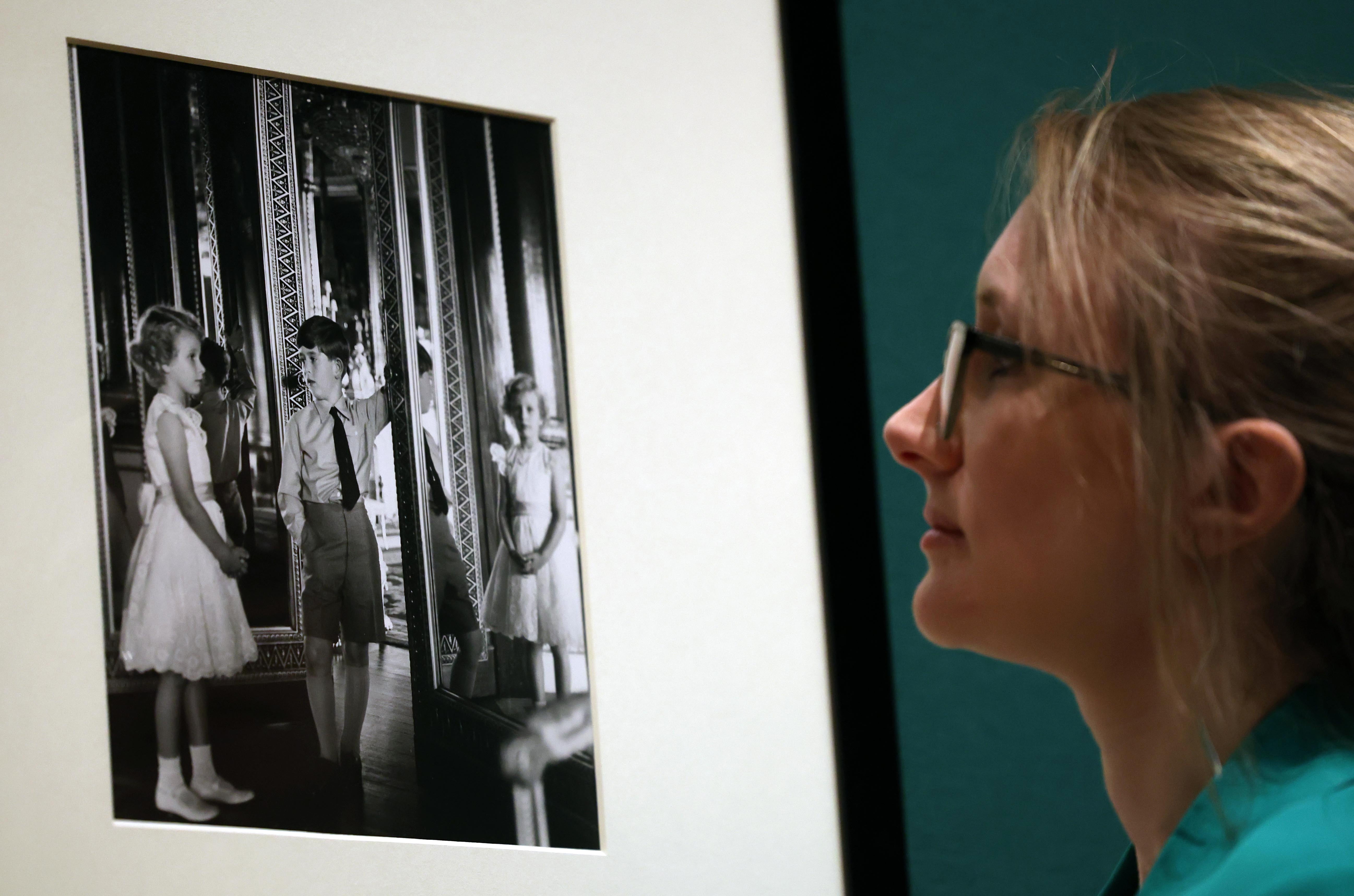 A gallery worker views a photograph of Princess Anne and Prince Charles by Anthony Armstrong-Jones