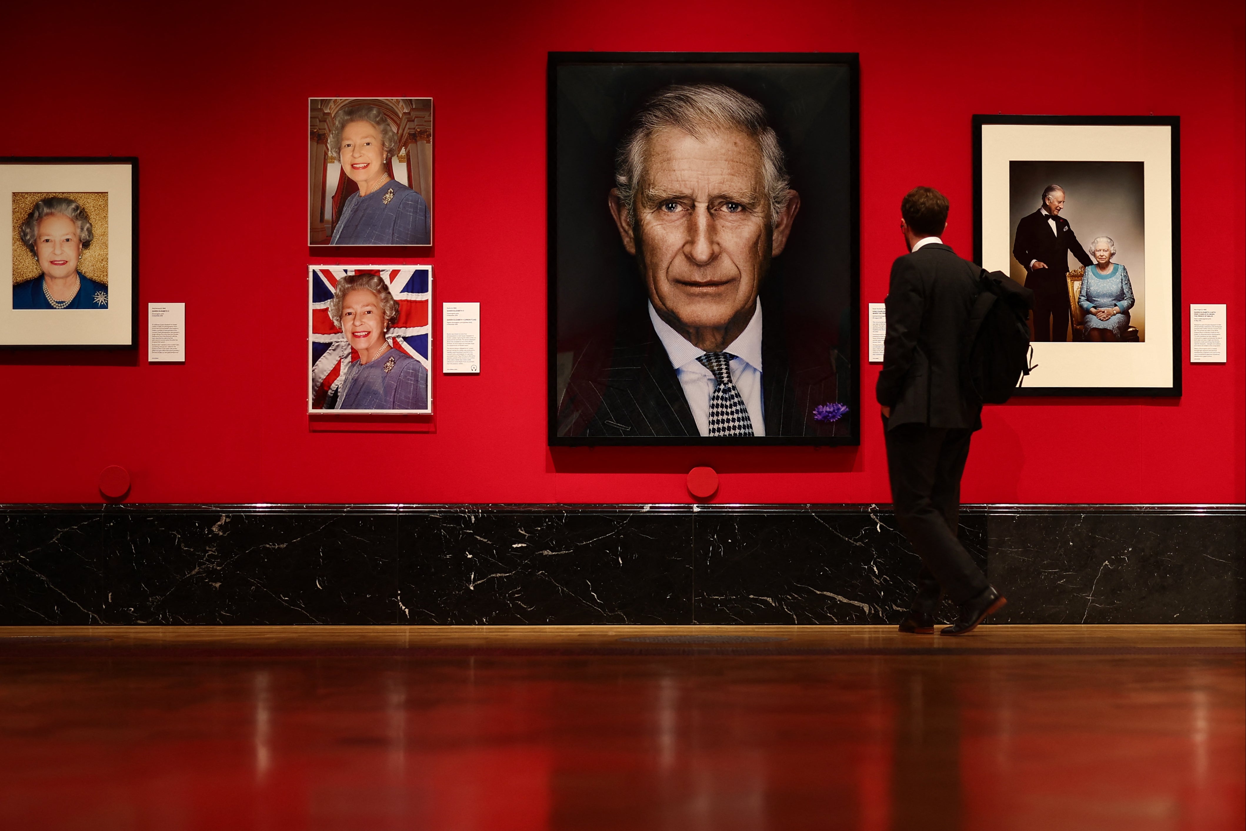 A visitor looks at photographs of Britain's King Charles III