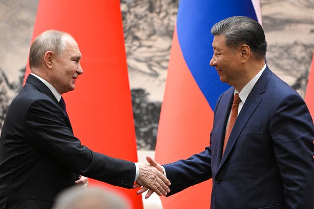 <p>Vladimir Putin and Xi Jinping shake hands for the cameras following their talks in Beijing on Thursday</p>