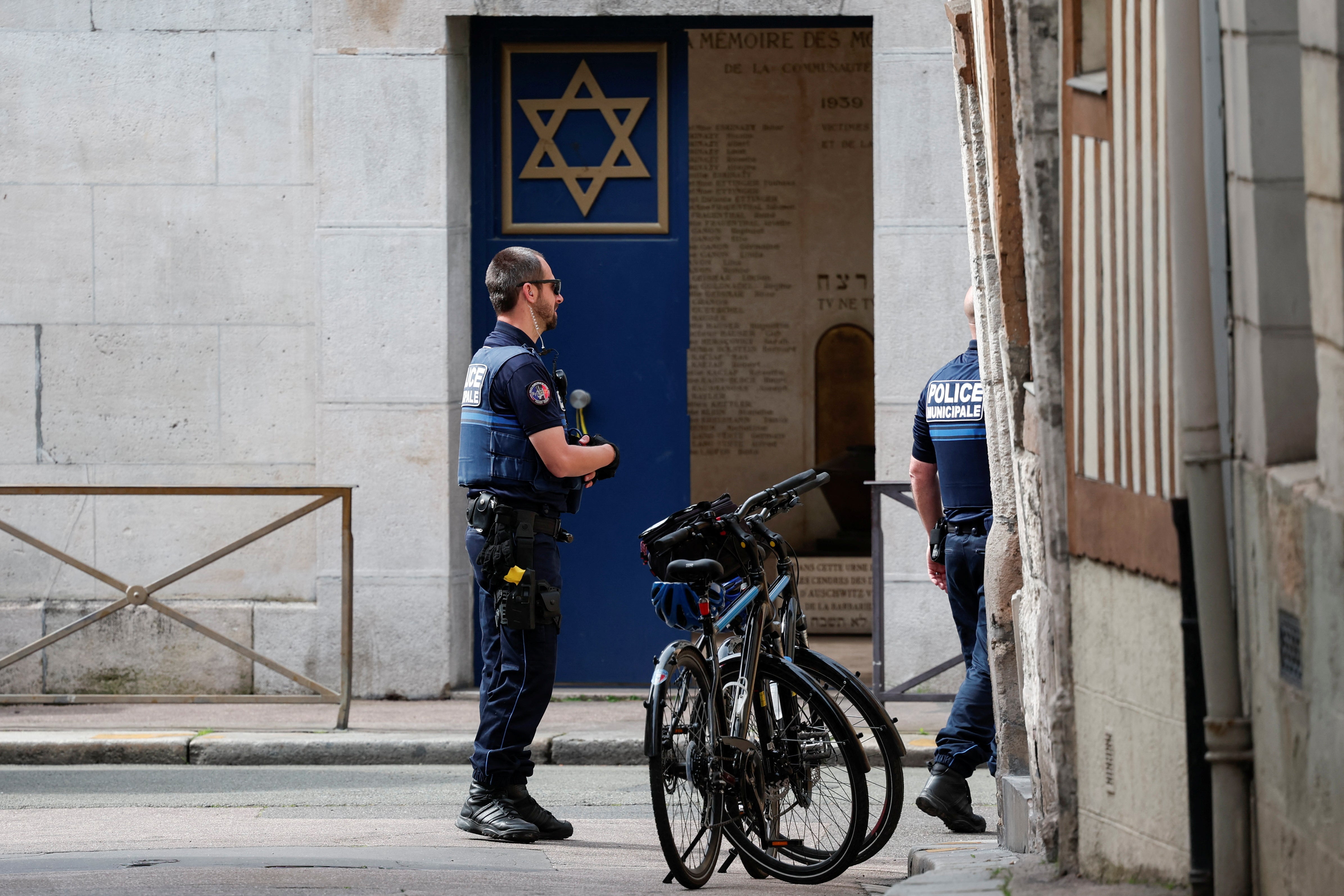 French police work near a door with the Jewish Star of David symbol after officers shot dead an armed man earlier who set fire to the city's synagogue in Rouen,