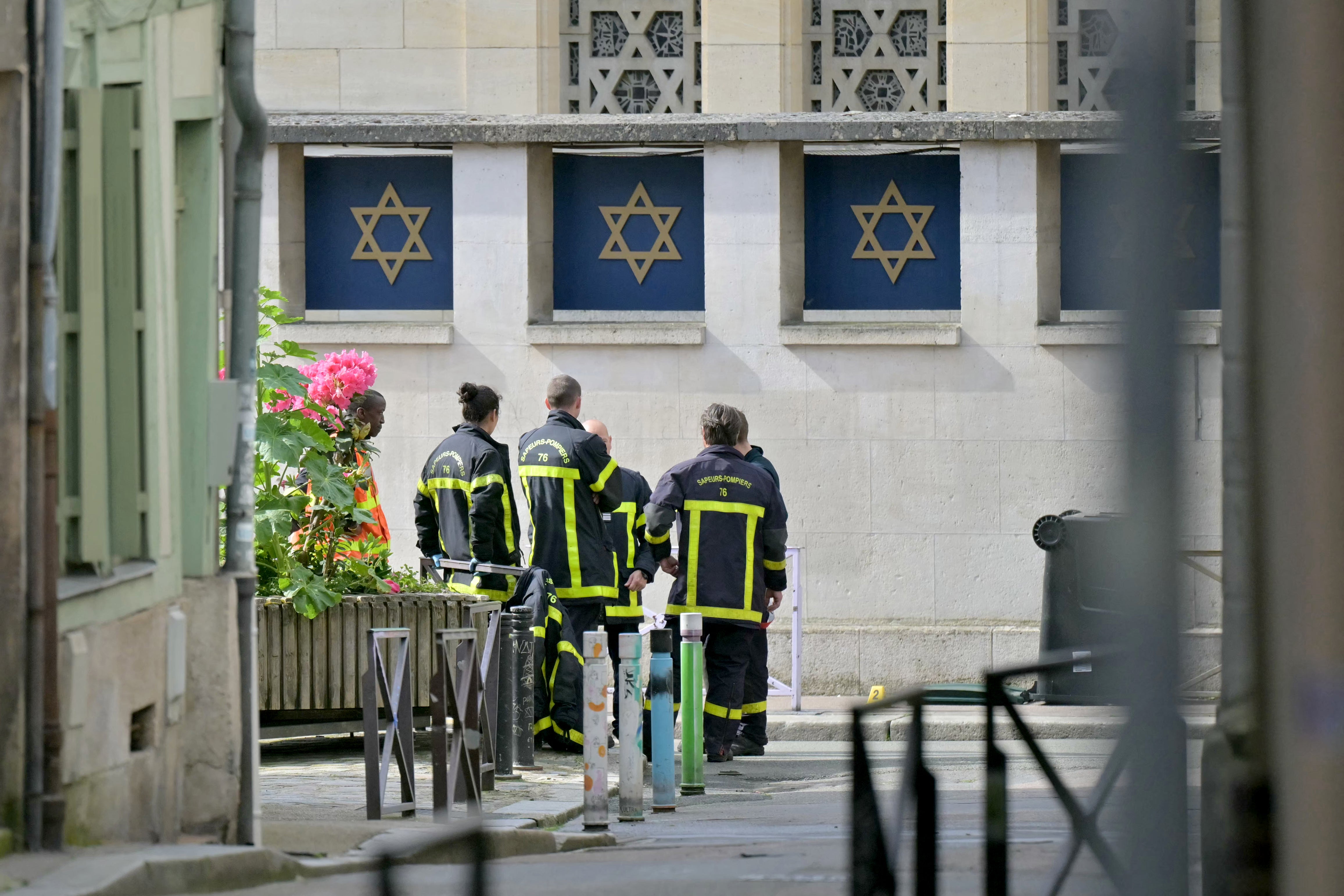 Fire brigade members stand by a synagogue in the Normandy city of Rouen where French police have killed earlier an armed man who was trying to set fire to the building