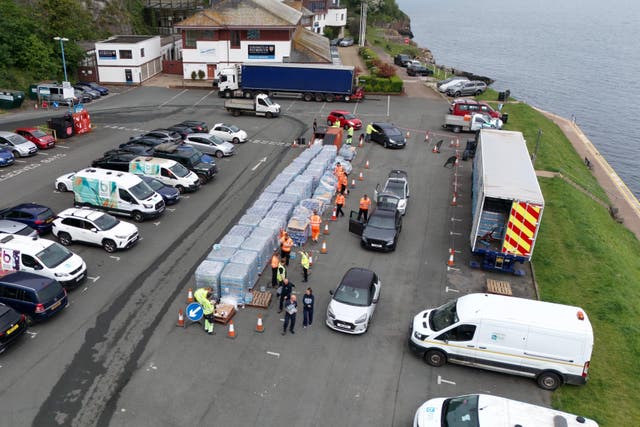 <p>A drone view of people collecting bottled water at Freshwater car park in Brixham on Friday</p>