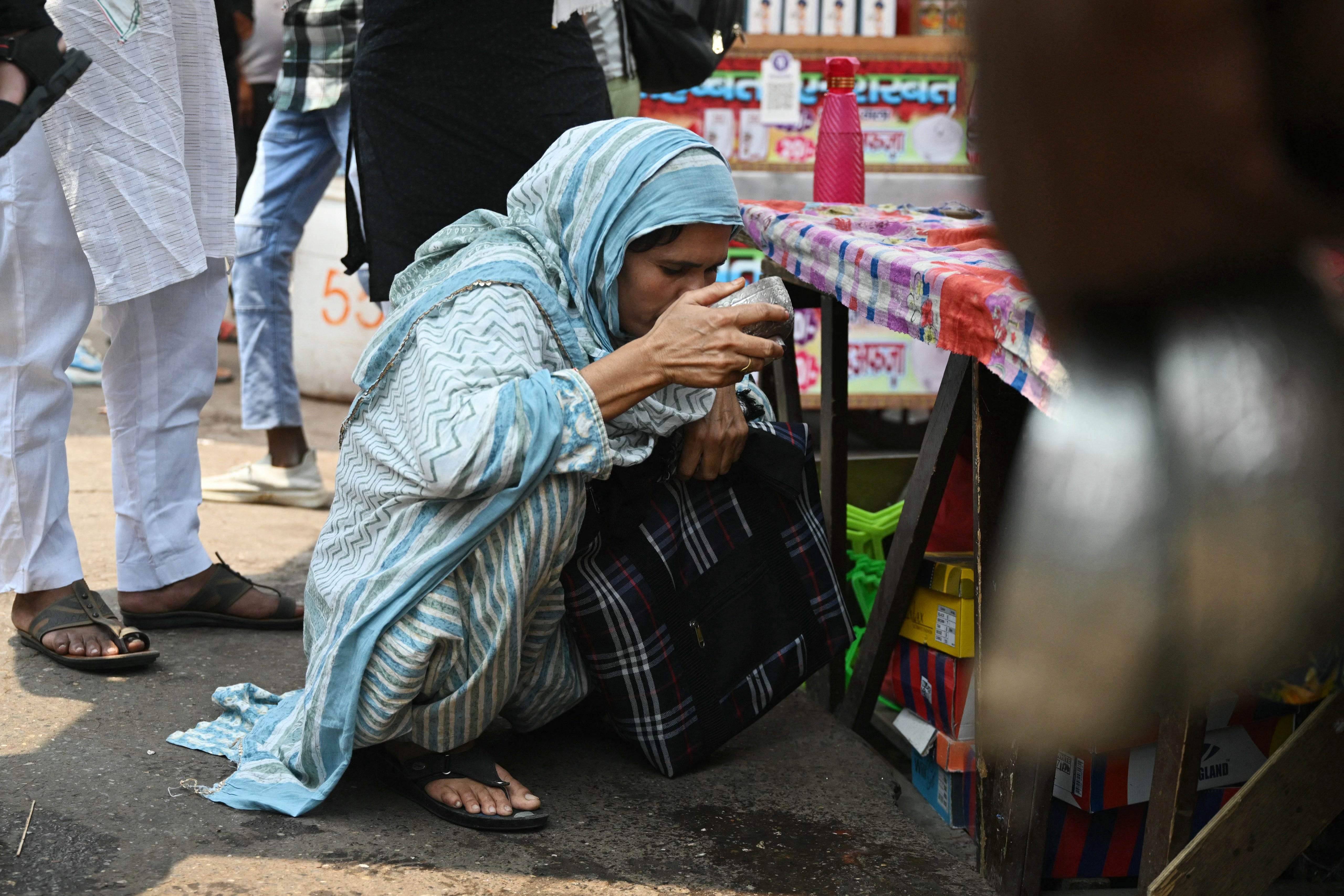 <p>A man quenches his thirst in front of the Jama Masjid during a hot summer day in the old quarters of New Delhi on May 17, 2024. </p>