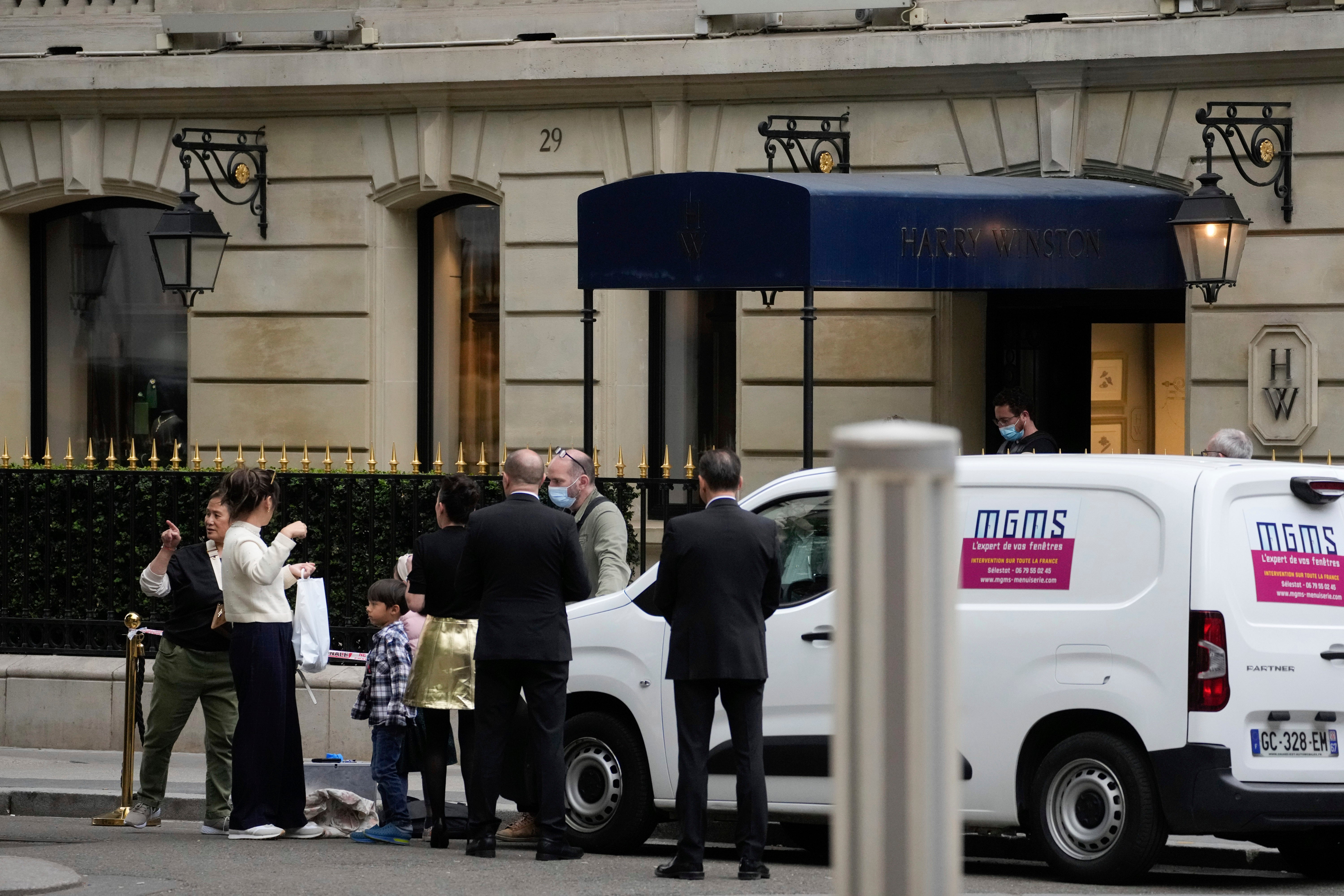 People stand by the entrance of the Harry Winston jewelry after a robbery in Paris, Saturday, May 18, 2024