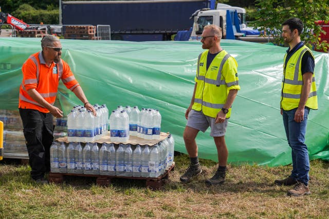 <p>South West Water staff and volunteers distribute water to the public at a water collection point on May 18, 2024 in Brixham, England</p>