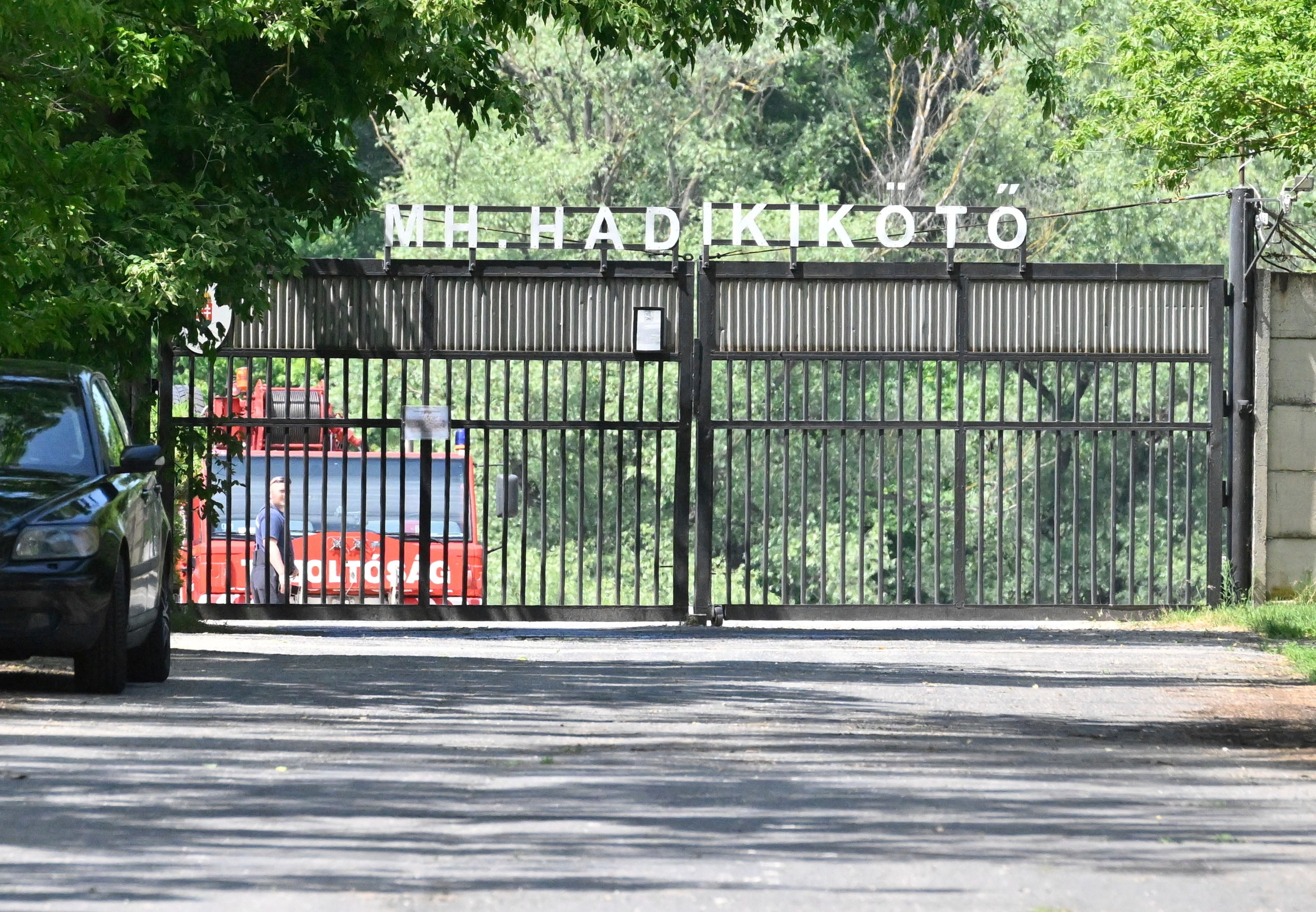 A car of the diving service of the fire brigade is parked behind the closed gate of a military port