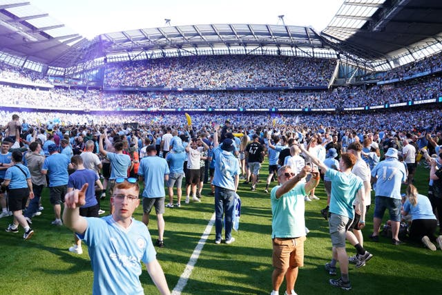 Manchester City fans invade the pitch after seeing their team clinch a fourth successive Premier League title (Martin Rickett/PA)