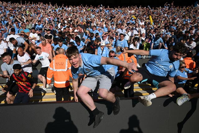 <p>Manchester City fans invade the pitch at the full-time whistle</p>