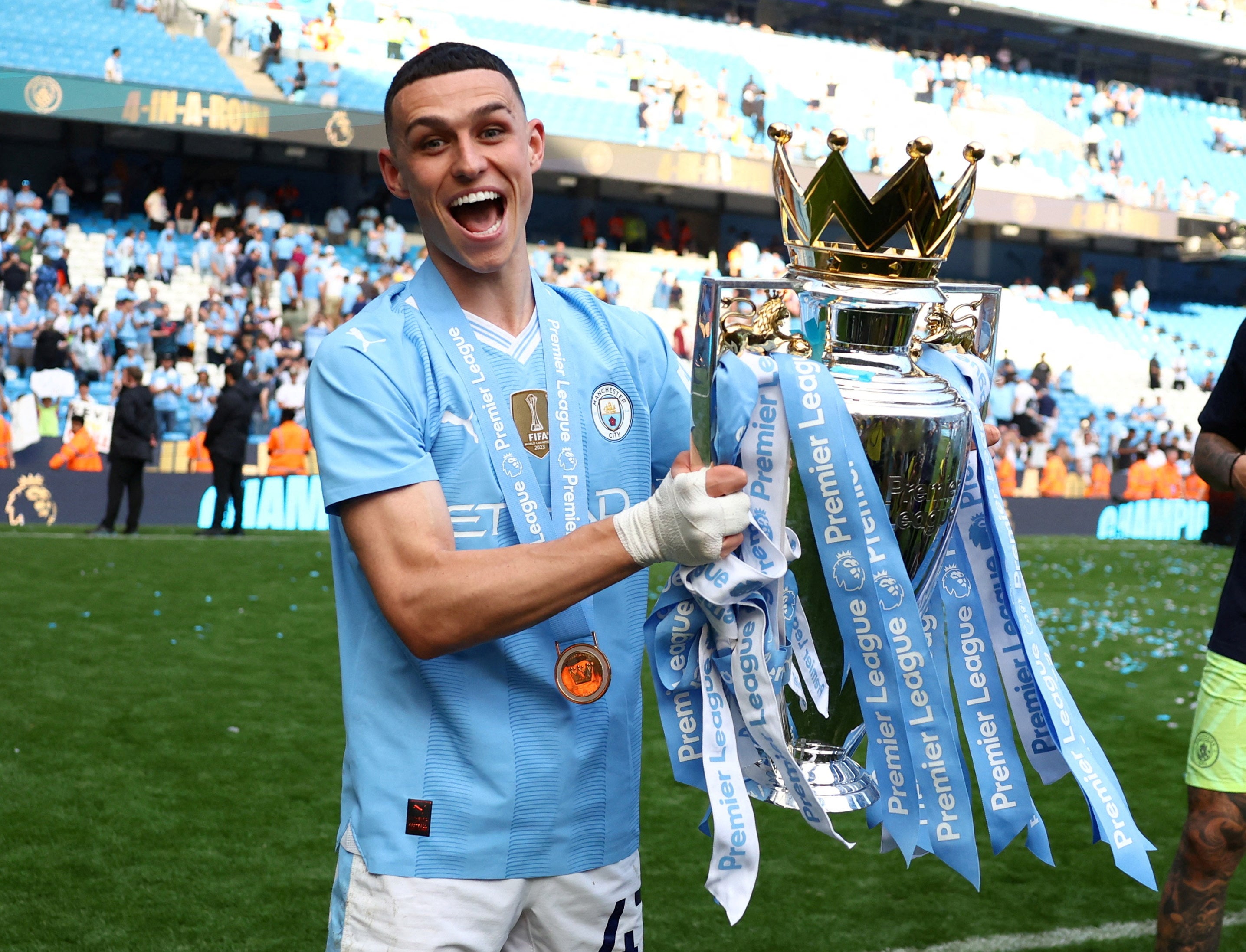 Foden poses with the Premier League trophy