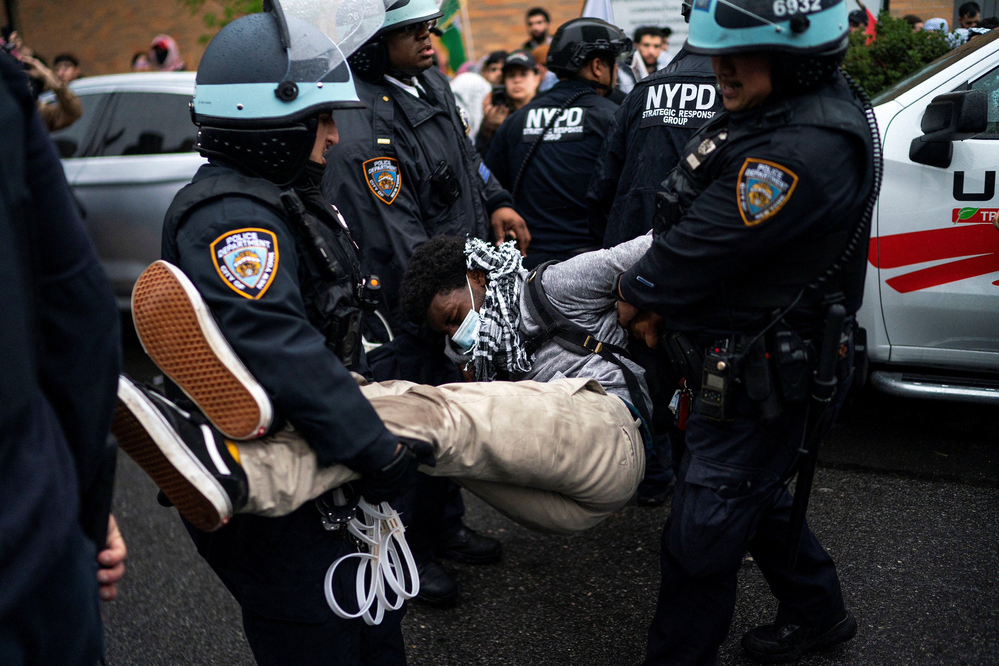 New York Police Department officers arrest a demonstrator during the protest in Brooklyn on 18 May