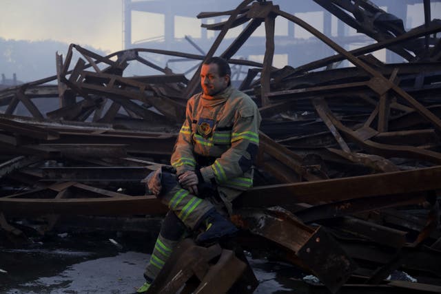 <p>A Ukrainian firefighter takes a rest after putting out a fire in food warehouse after Russian missile strike to Odesa</p>