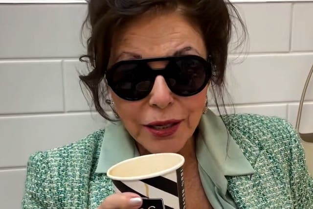 <p>Joan Collins sips on coffee while shopping in Marks and Spencer.</p>