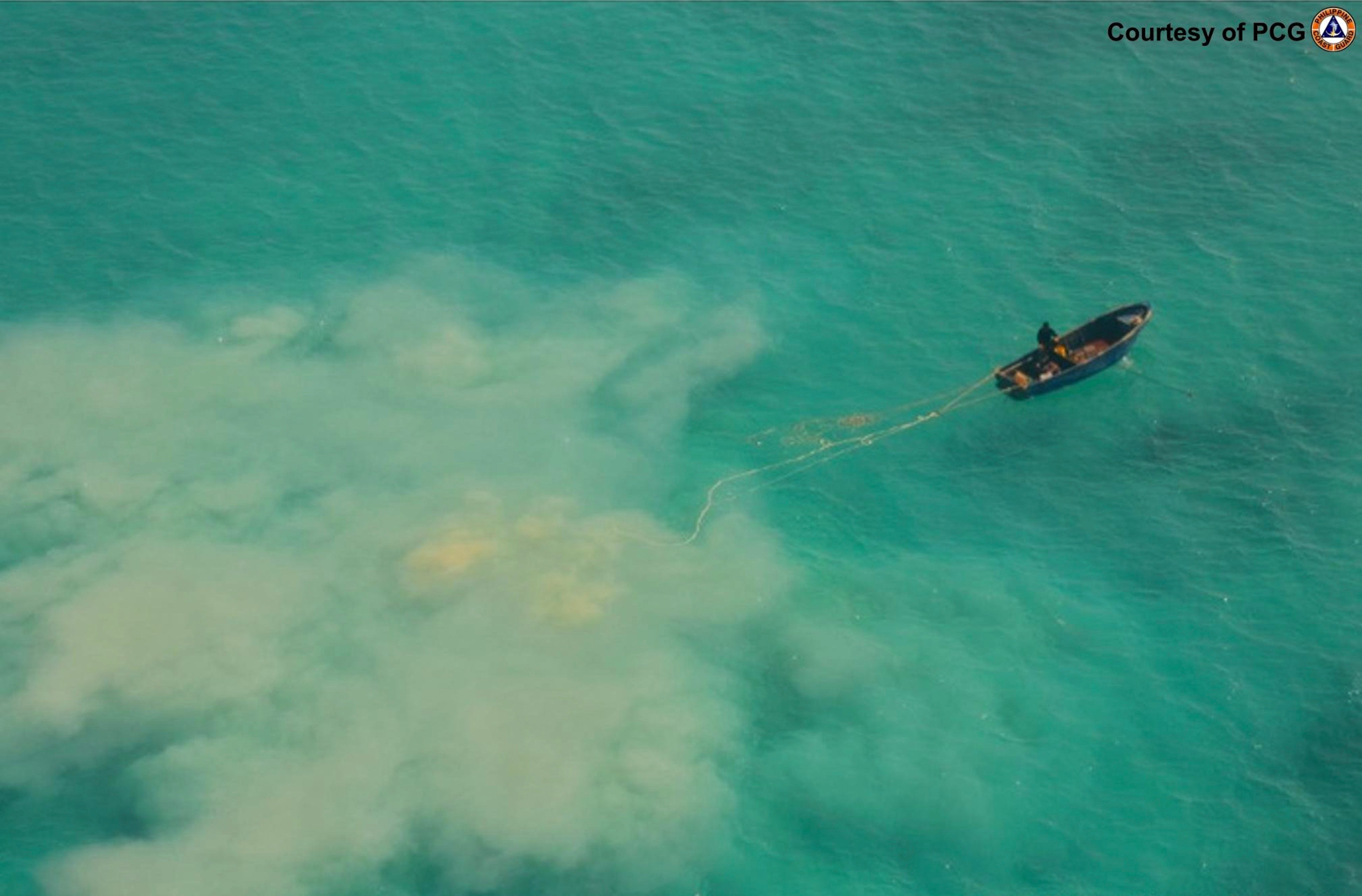 In this April 22, 2019 handout photo provided by the Philippine Coast Guard, Chinese service boats scour the seabed as they search for giant clams in the Scarborough shoal, at the disputed South China Sea, the Philippine Coast Guard said