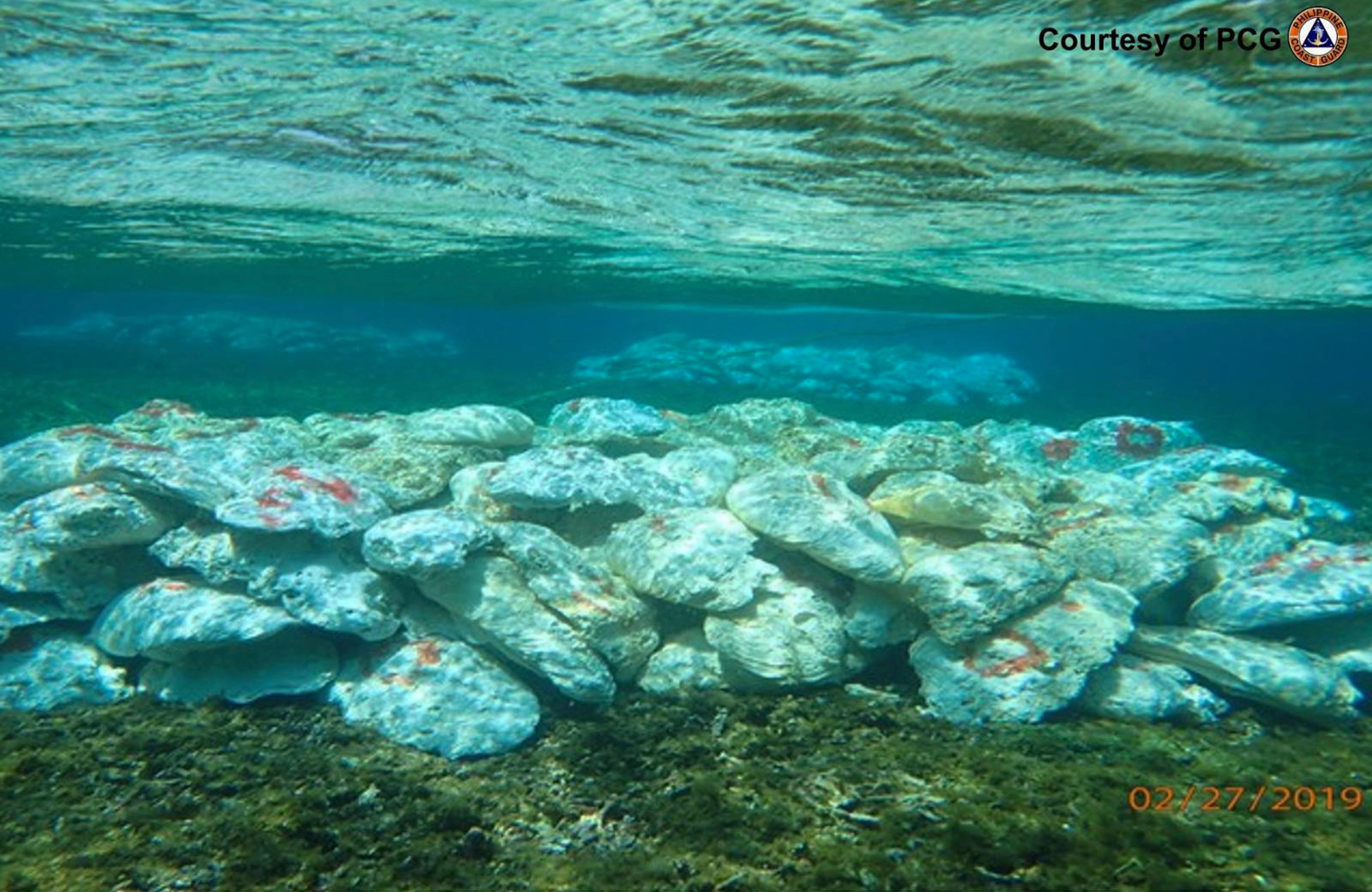 This February 27, 2019 handout photo provided by the Philippine Coast Guard shows marked giant clams in several piles made by Chinese militias at the shallow part of the Scarborough shoal, at the disputed South China Sea, the Philippine Coast Guard said