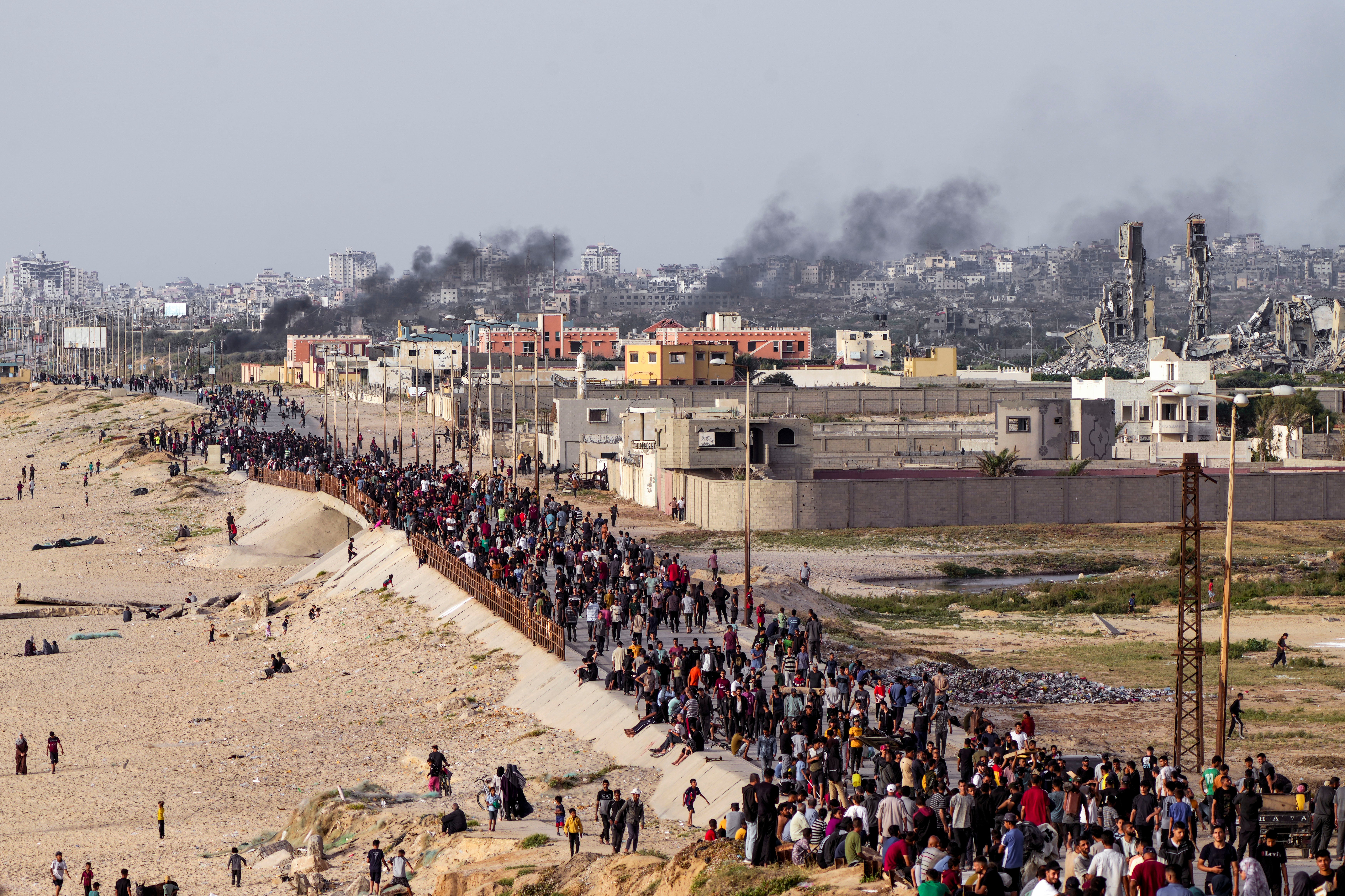 Palestinians wait for aid trucks to cross in central Gaza Strip on Sunday amid widespread famine in the enclave