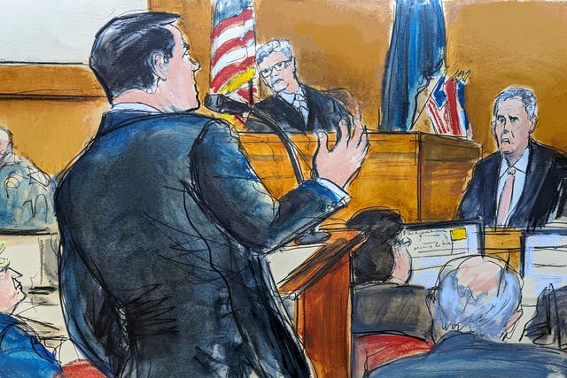 <p>Donald Trump, far left, watches as defense attorney Todd Blanche, at podium, cross examines Michael Cohen on the witness stand with Judge Juan Merchan presiding</p>