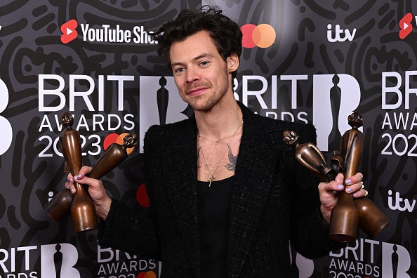Harry Styles poses with a handful of Brit Awards in 2023