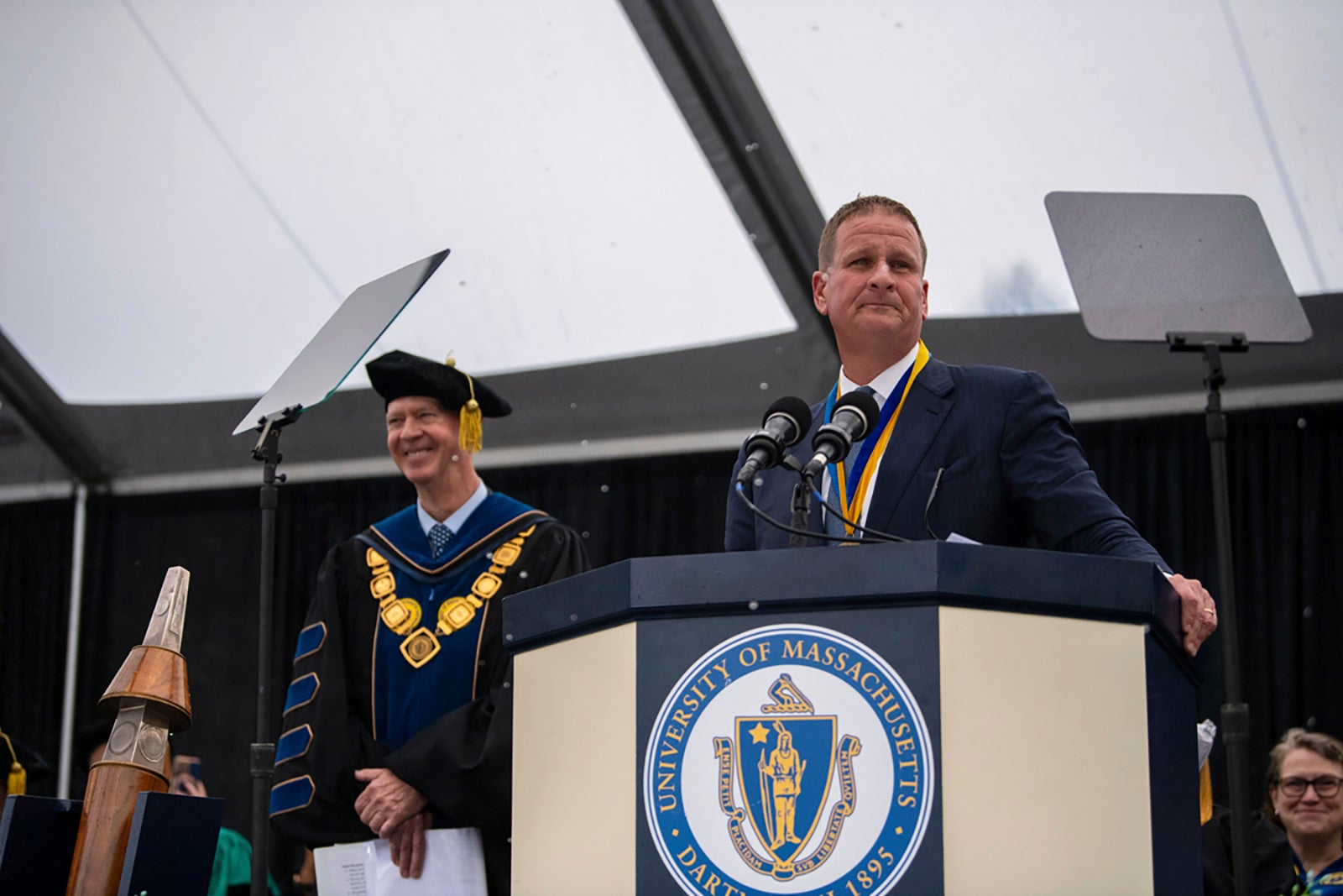 Rob Hale surprised the graduating class by pointing to a nearby truck holding envelopes stuffed with cash before security guards lugged cash-filled duffel bags onto the stage.