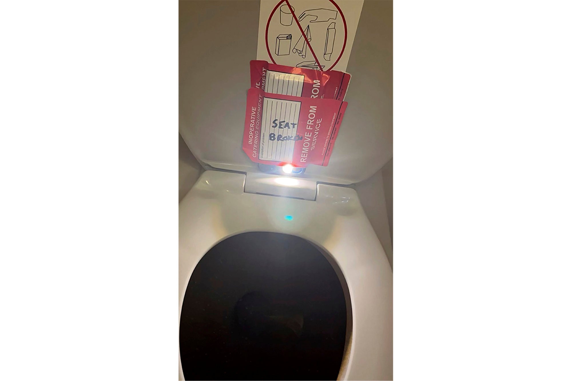 An iPhone is taped to the back of a toilet seat on an American Airlines flight