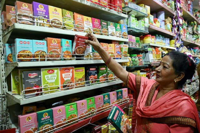 <p>A shopper looks at packets of MDH and Everest spices at a store in Amritsar on 21 May 2024</p>