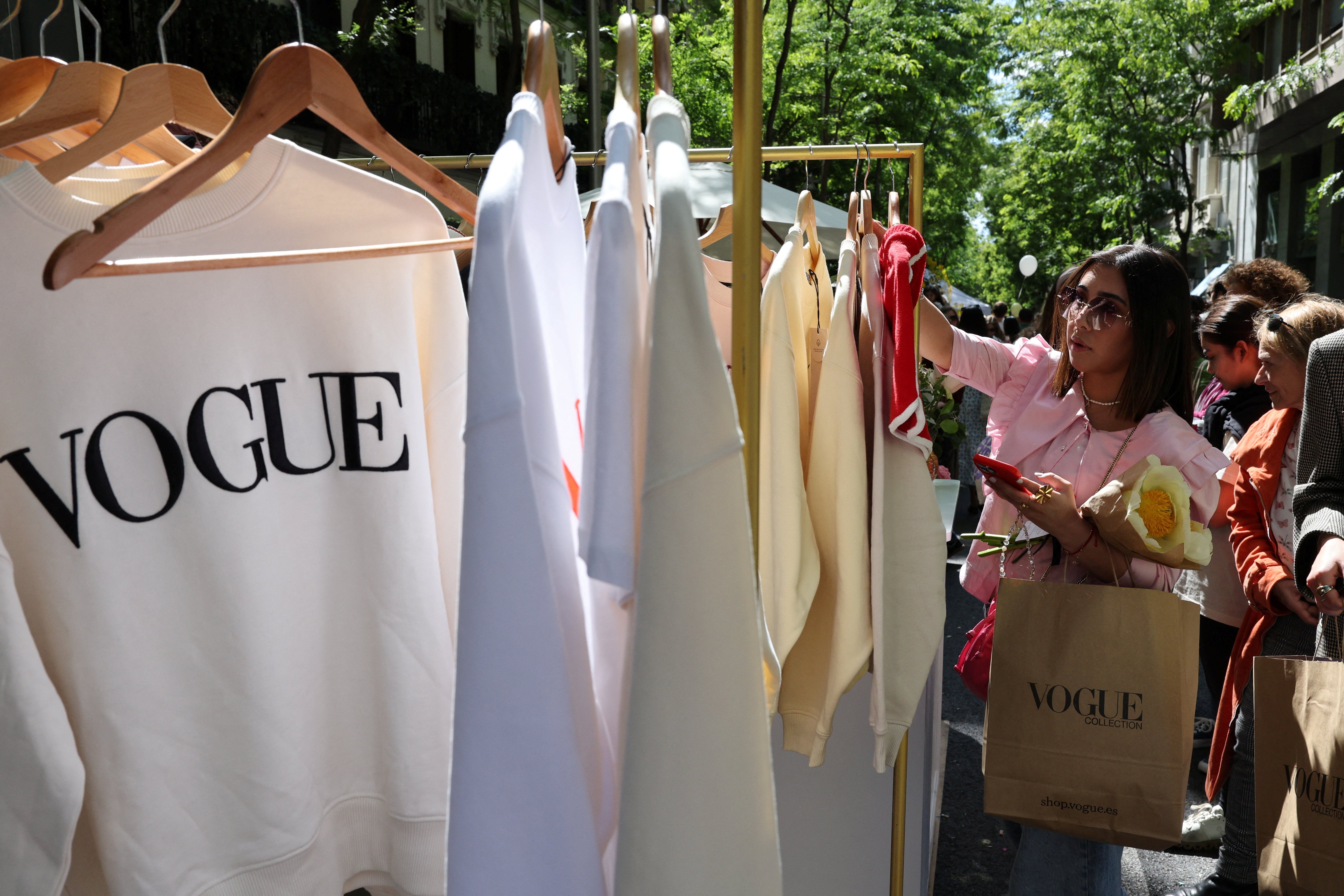 A person looks at clothes at an outdoor market in the downtown district of Salamanca, Spain