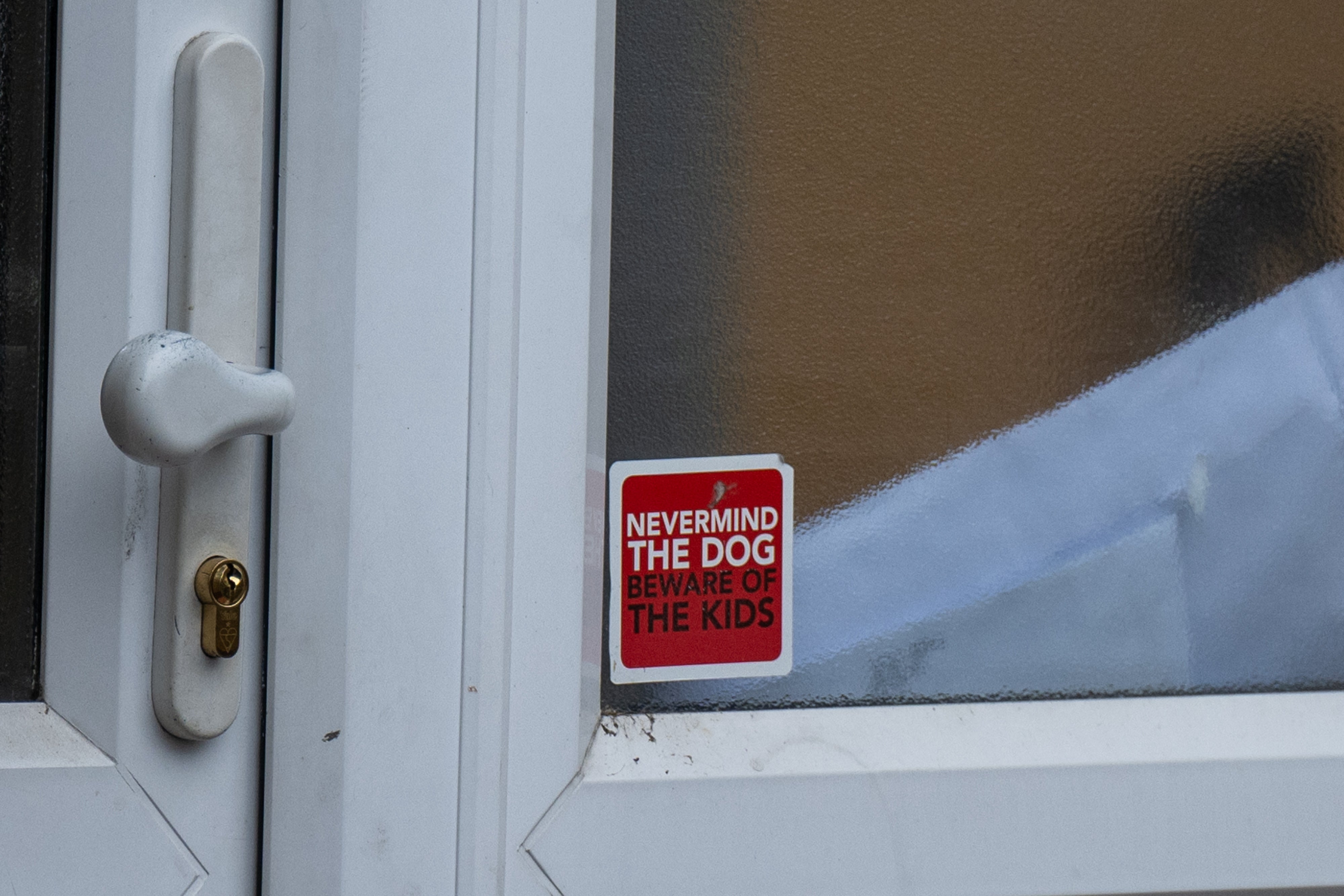 The sticker in a window next to the front door of the home where a woman was killed by her two dogs in Hornchurch