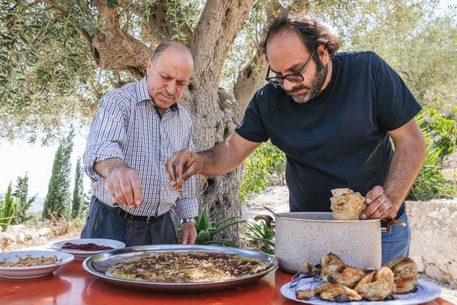 <p>Kattan, right, making the Palestinian dish musakhan with restaurant owner Abu Mohammad</p>