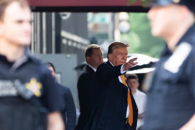 Former president Donald Trump waves while leaving Trump Tower on his way to Manhattan criminal court on 21 May 2024