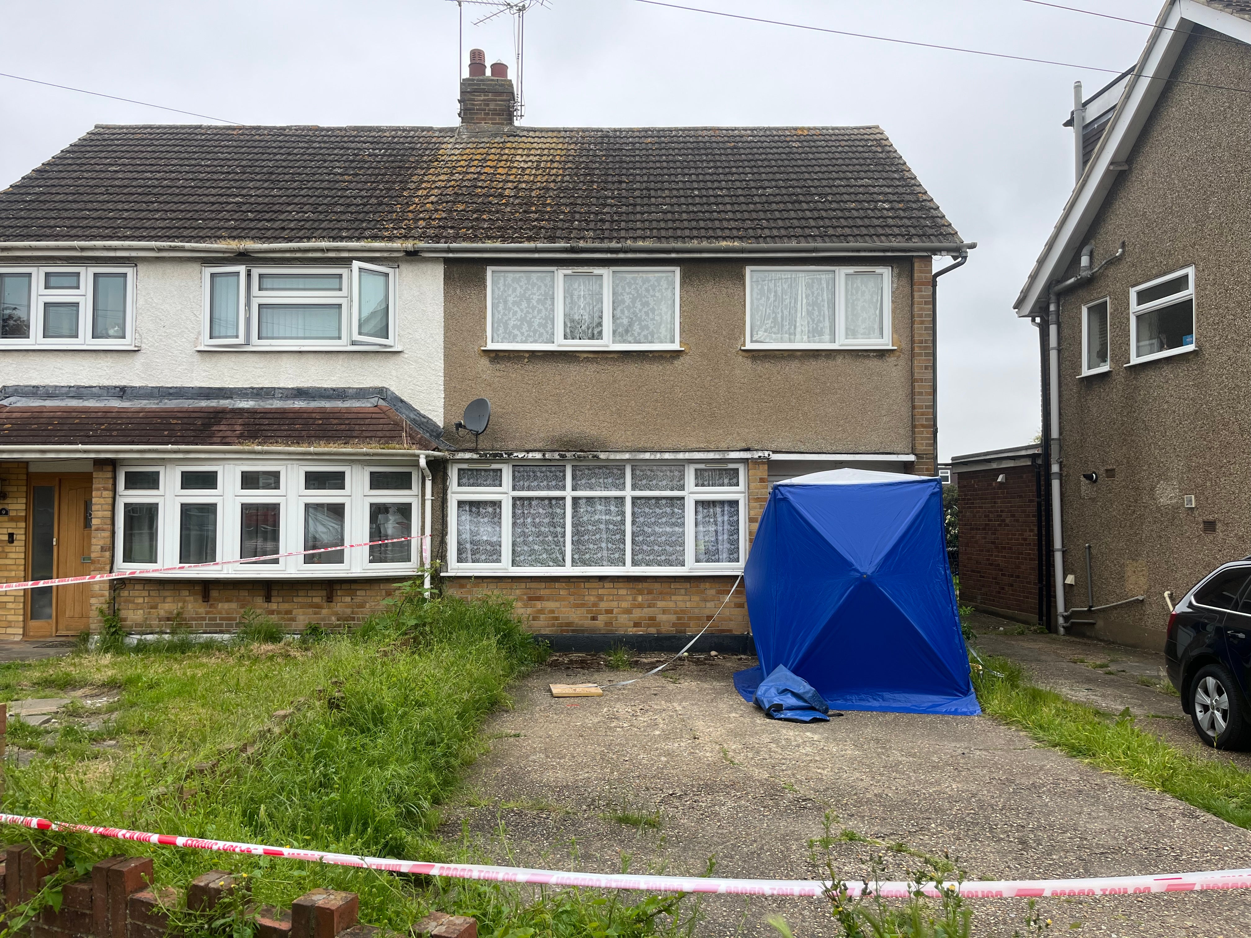 A blue forensic tent outside the entrance to the home