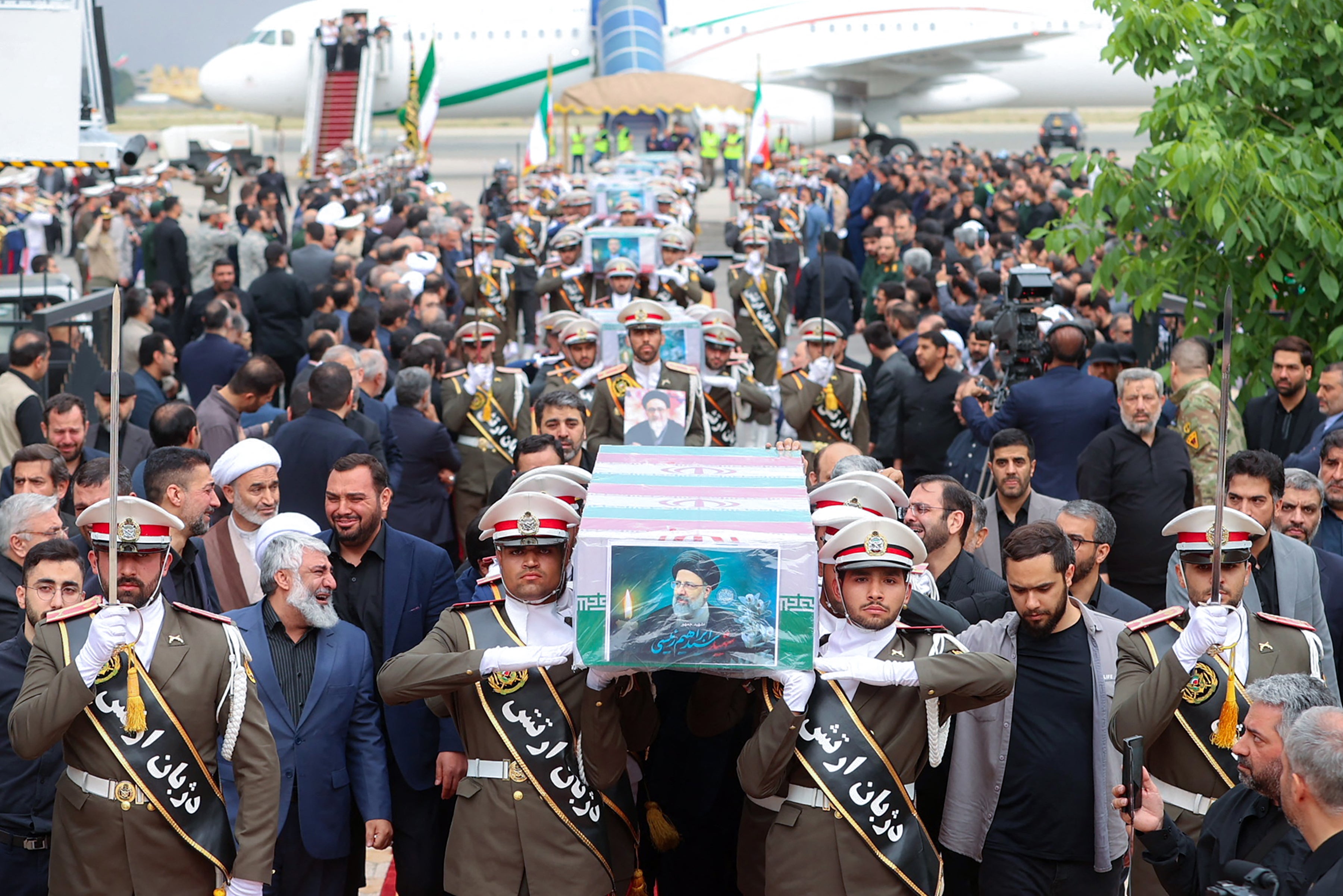 This handout picture provided by the Iranian president's office shows honour guards carrying the coffin of late Iran's President Ebrahim Raisi as officials weep in the background