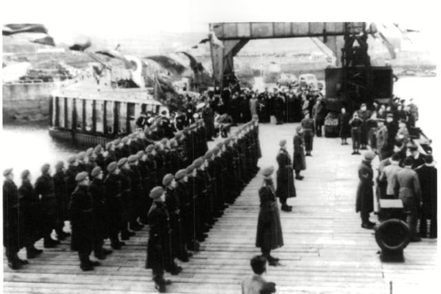<p>German troops stand in line at Alderney quay </p>