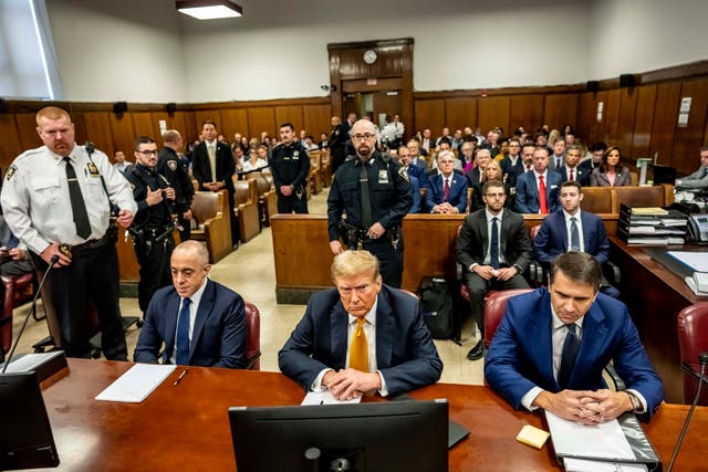 Former President Donald Trump, center, sits in Manhattan Criminal Court with his attorneys Emil Bove, left, and Todd Blanche on May 21