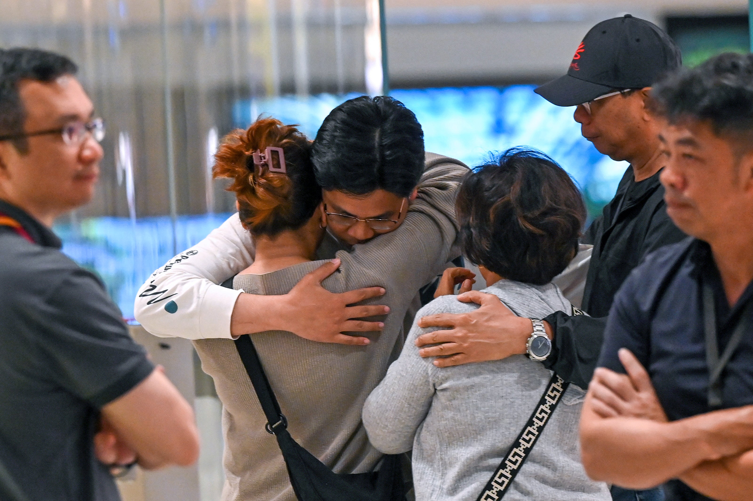 Passengers of Singapore Airlines flight SQ321 from London to Singapore, which made an emergency landing in Bangkok, greet family members upon arrival at Changi Airport in Singapore on 22 May 2024