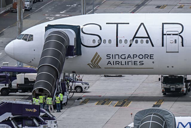 <p>Officials enter the Singapore Airlines Boeing 777-300ER airplane that made an emergency landing in Bangkok due to severe turbulence</p>