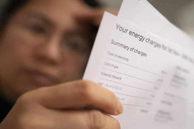 A person holding an energy bill (PA)