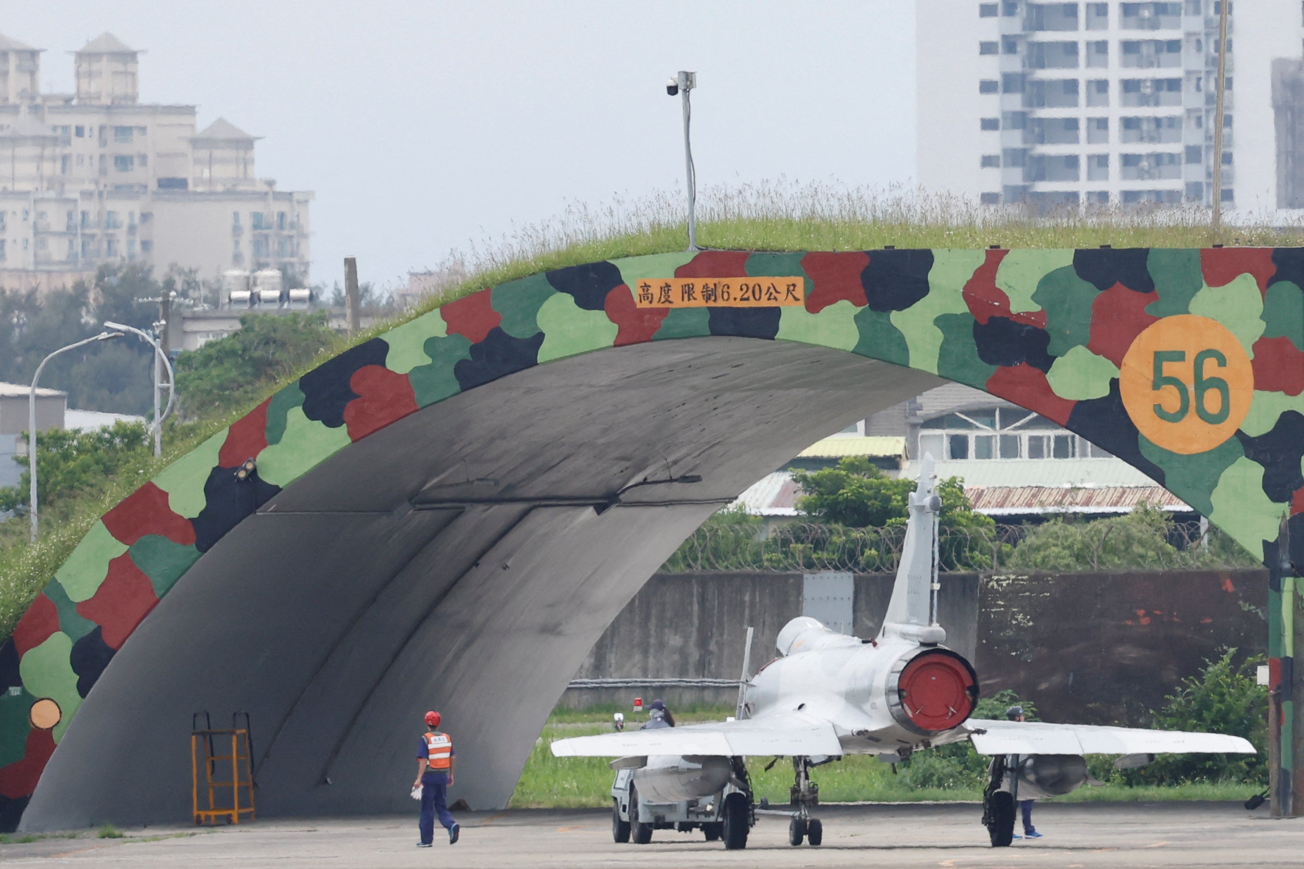 A member of ground staff walks next to a Taiwan Air Force Mirage 2000-5 at Hsinchu