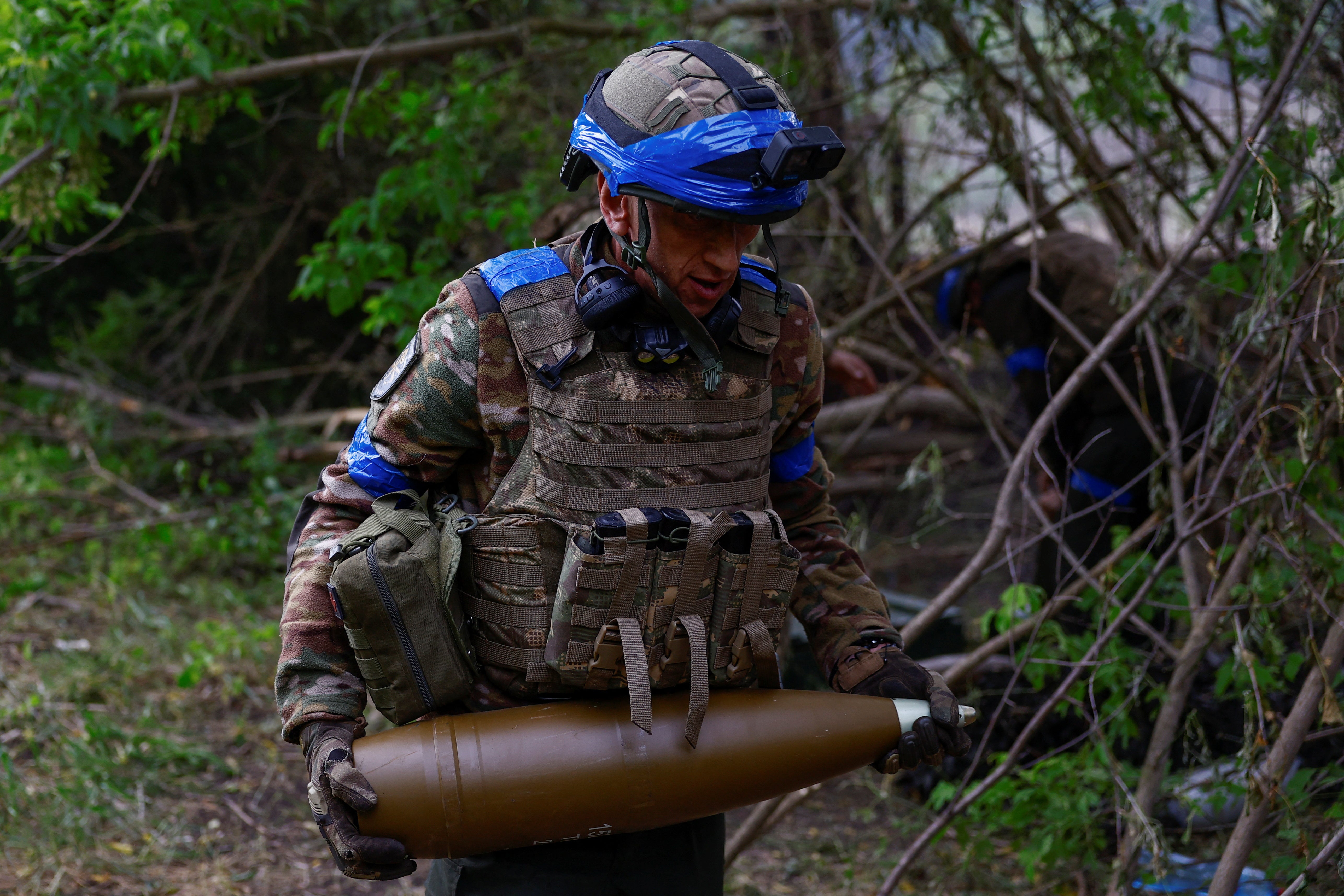 Ukrajinský voják připravuje střelu z houfnice ráže 152 mm, která má být vypálena na ruské síly v Charkově.