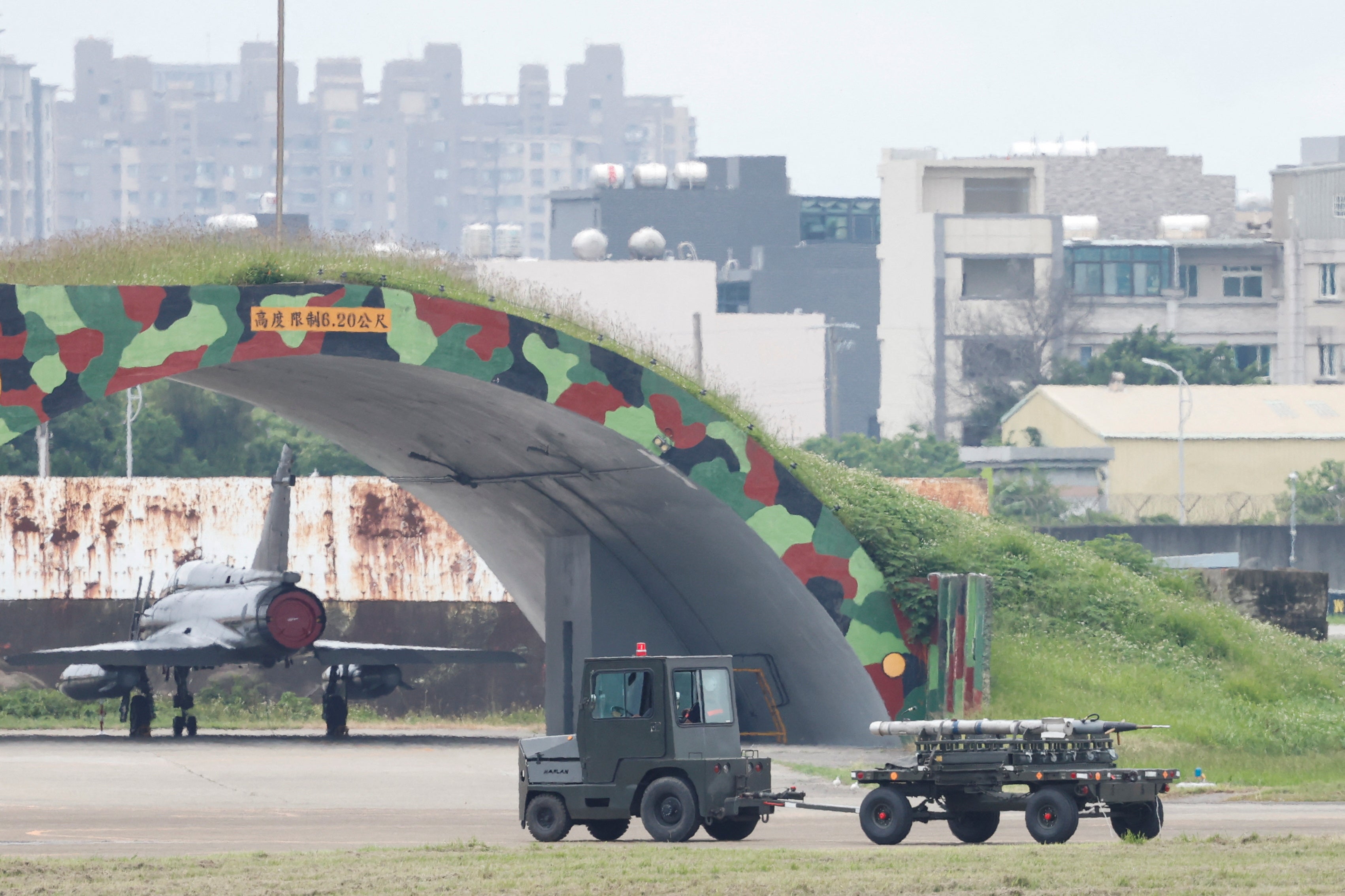 Ground staff members transport missiles near a Taiwan Air Force Mirage 2000-5 aircraft at Hsinchu Air Base, in Hsinchu