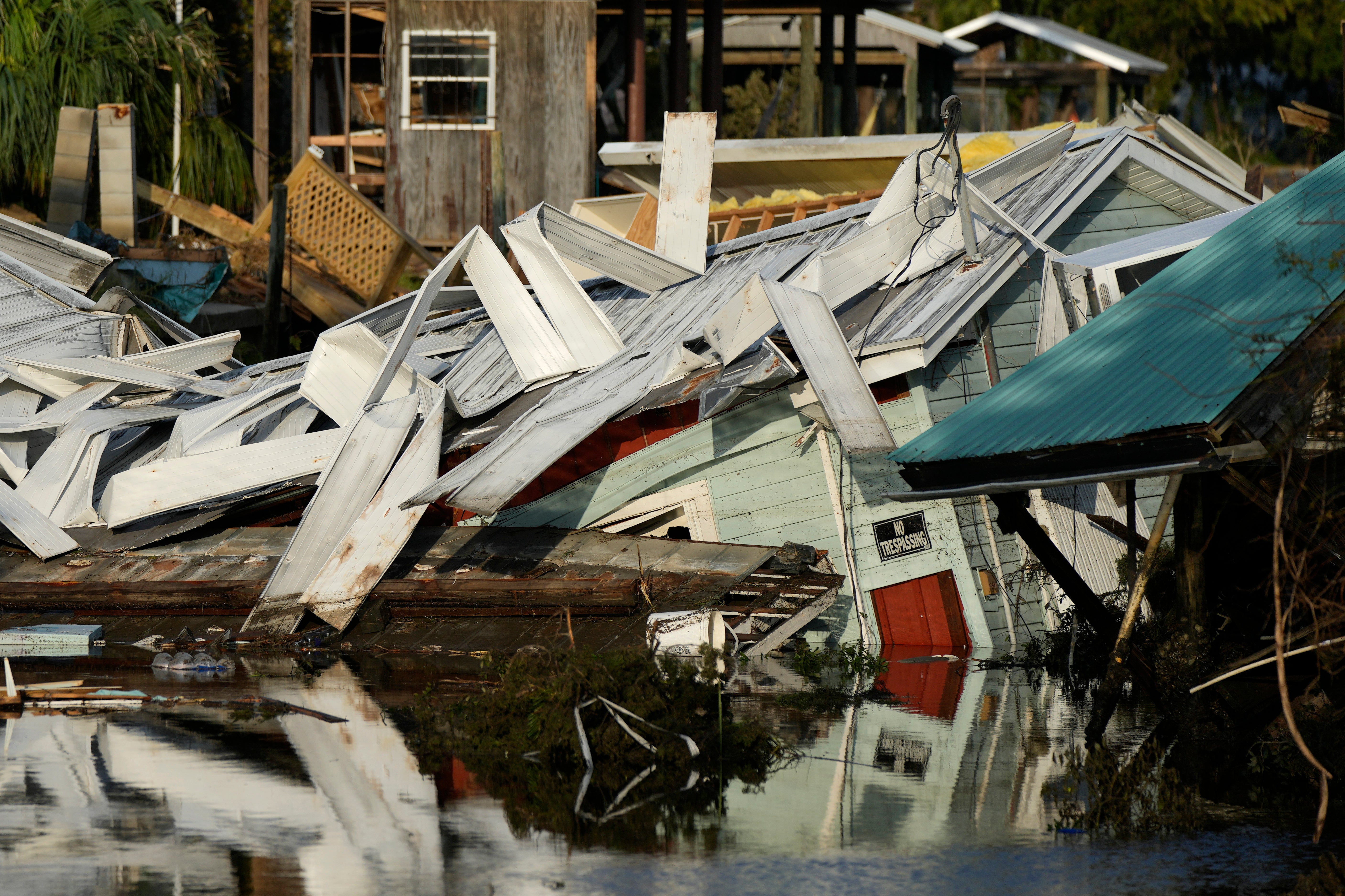 A home which came off its blocks sits partially submerged in a canal, in Horseshoe Beach