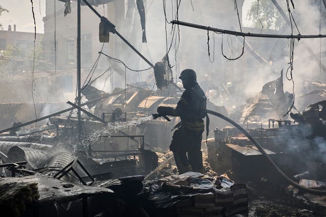Ukrainian rescuers work at the site of a shelling on a printing house in Kharkiv on May 23